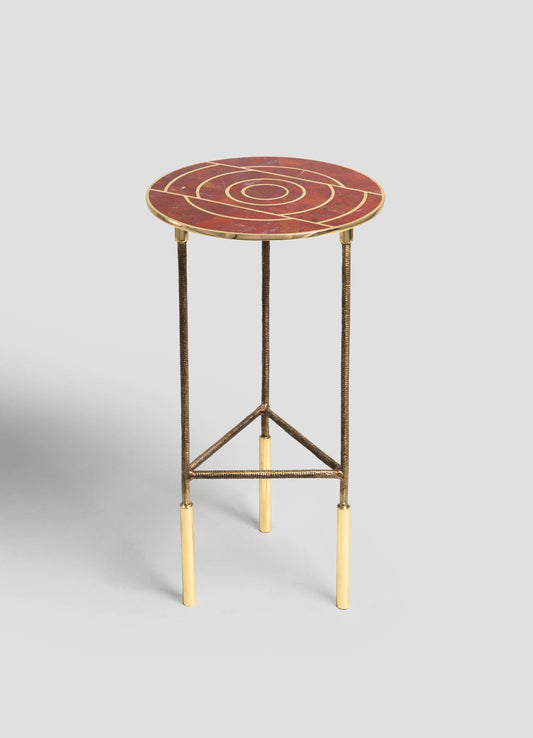 A small side table with a round marble top featuring a red and gold geometric pattern, supported by a metal frame with brass finish legs and brass accents.