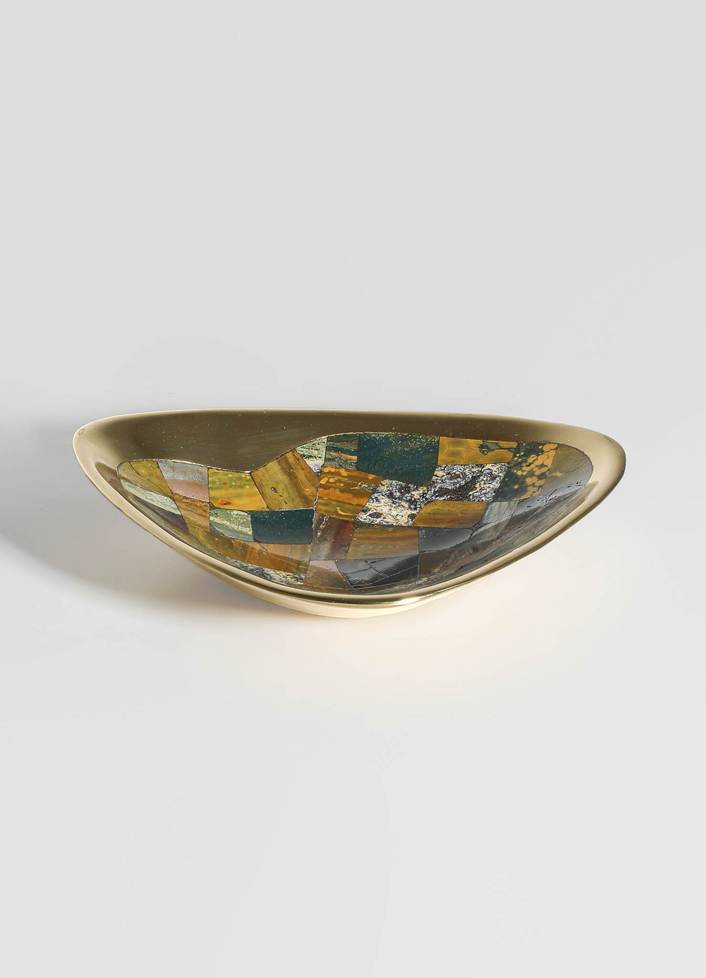 A decorative bowl with a brass exterior and an interior featuring multicolored mosaic patterns in earthy tones, combining geometric and abstract motifs for a contemporary style.