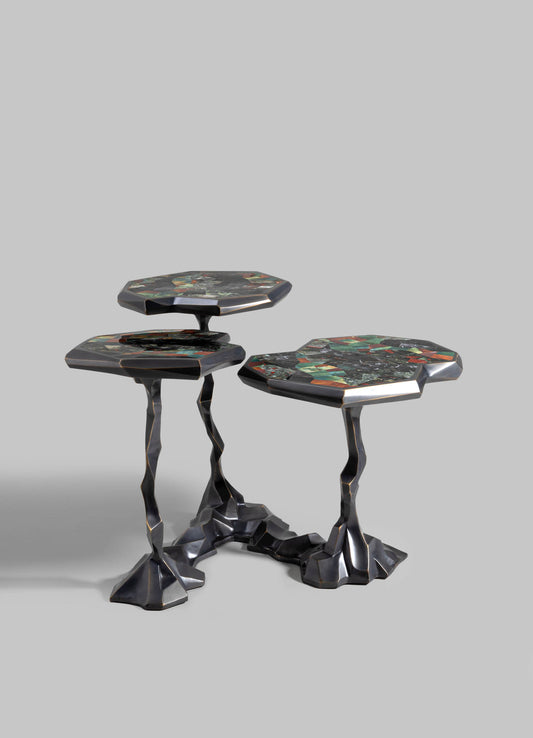 Set of three nesting tables with irregular, sculptural metal legs in a dark finish and multi-colored marble tops featuring a geometric pattern.