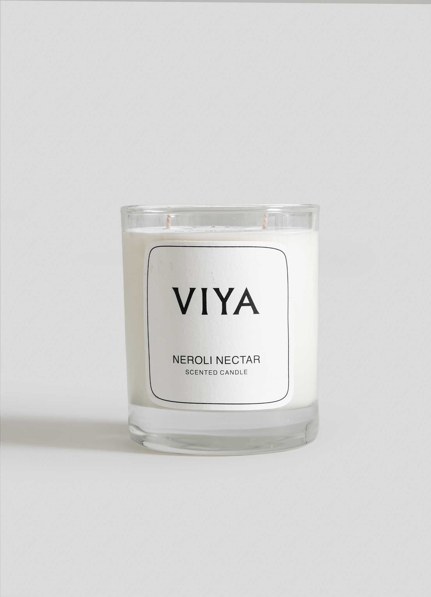 VIYA Neroli Nectar scented candle on a white background viya luxury wax candle stand