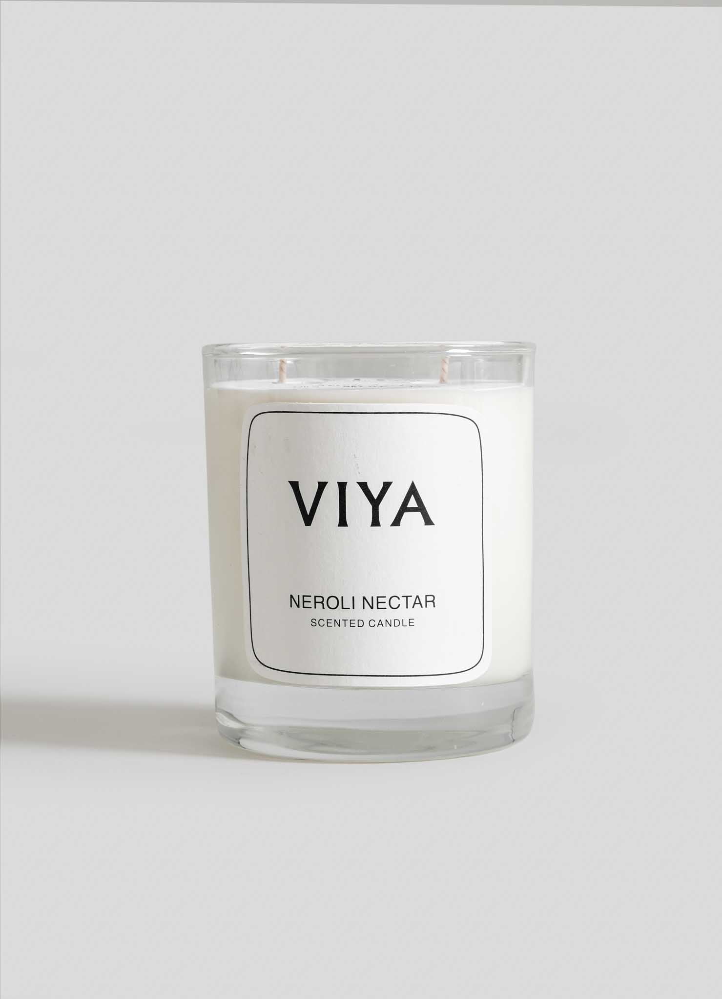 VIYA Neroli Nectar scented candle on a white background viya luxury wax candle stand