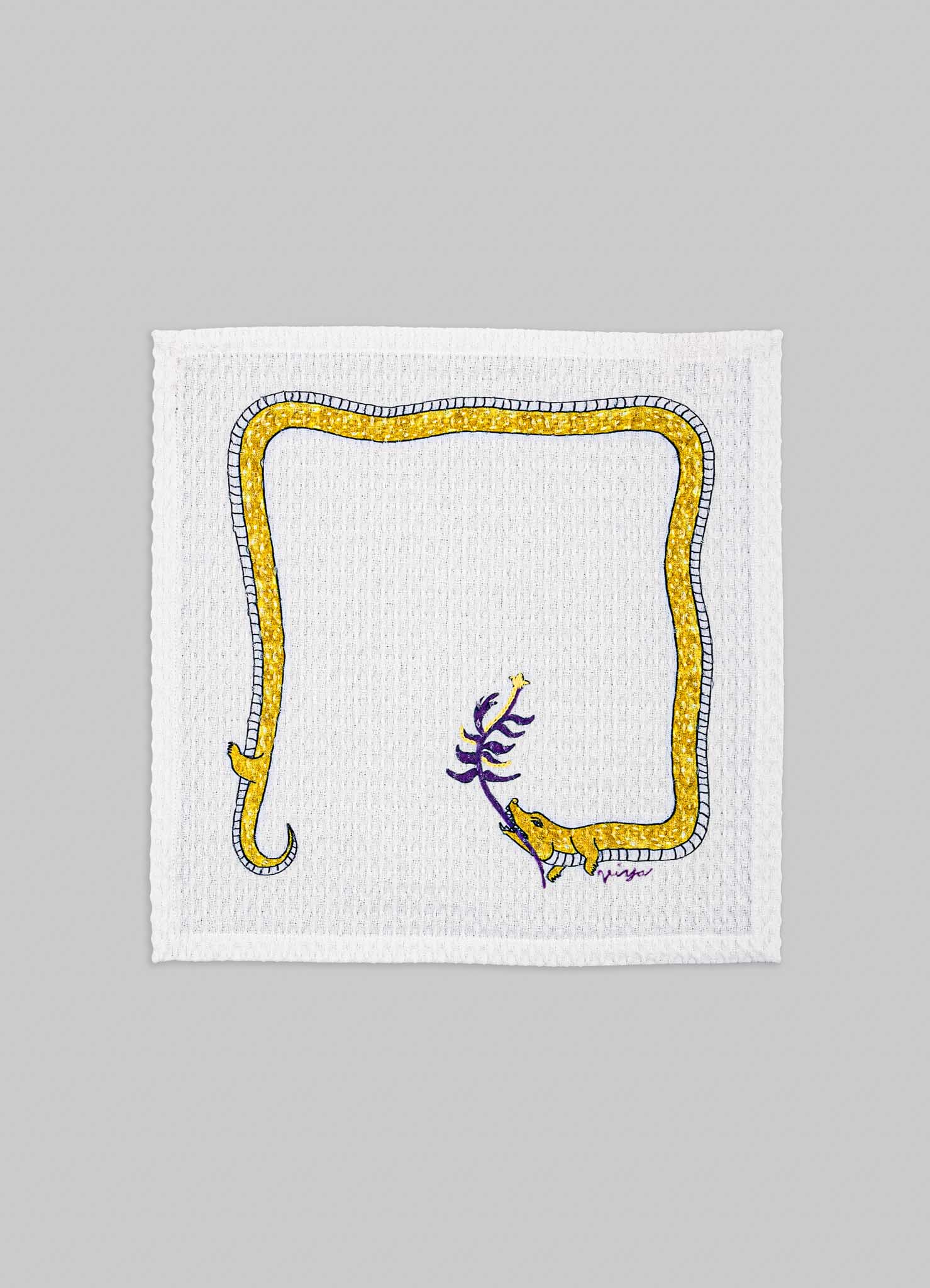 A white textured fabric square featuring a colorful embroidered design of a yellow snake with purple accents, coiled around a purple plant stem. The embroidery includes a border with yellow and dark blue stitching.