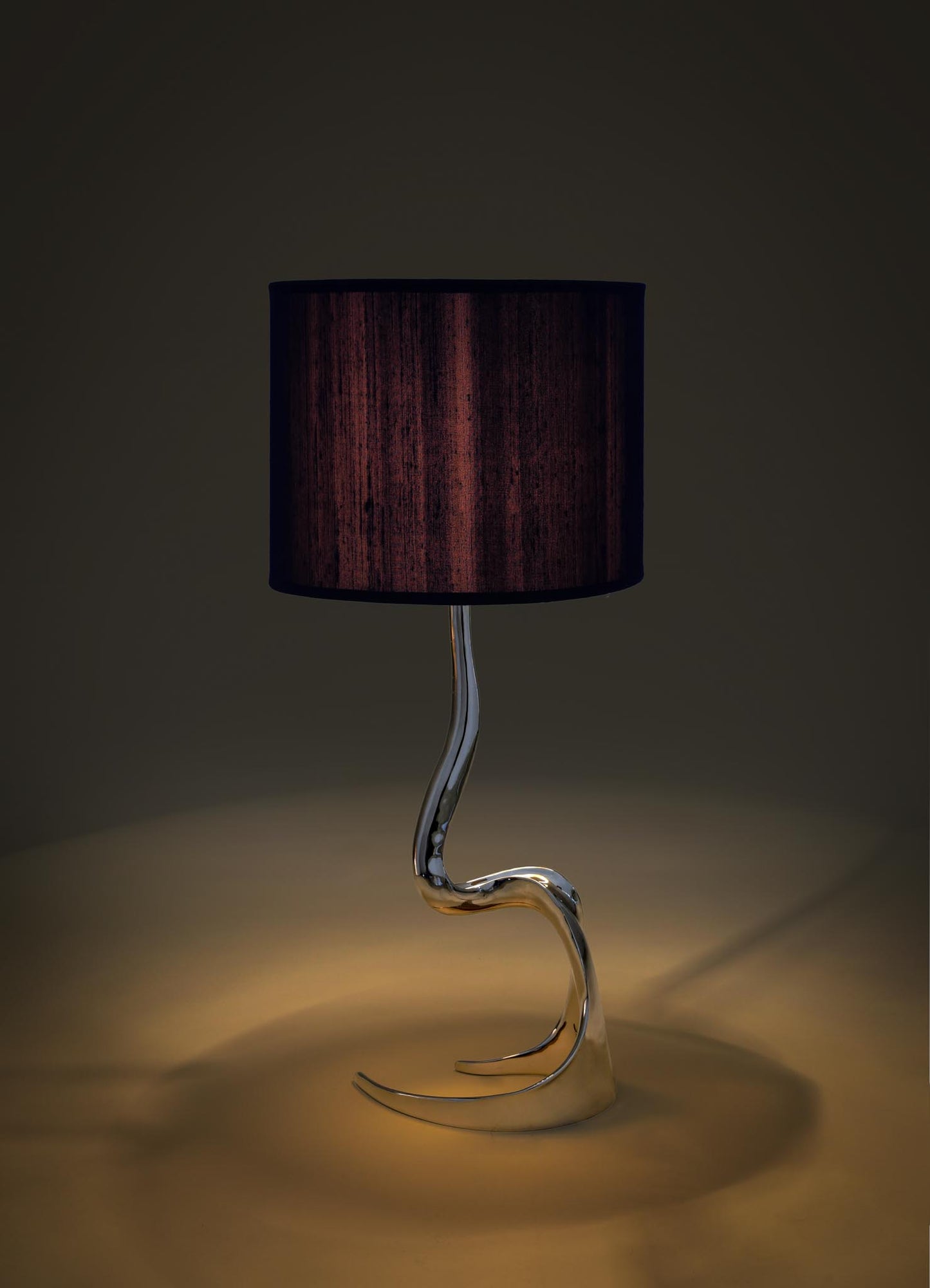 Modern table lamp with a black shade and curved glass base on a dark viya designer luxury table lamp background