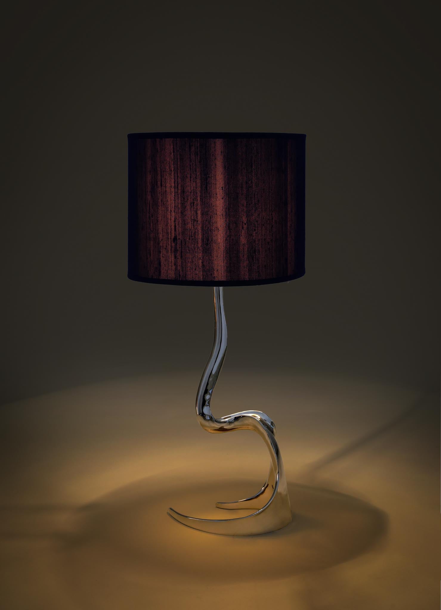 Modern table lamp with a black shade and curved glass base on a dark viya designer luxury table lamp background