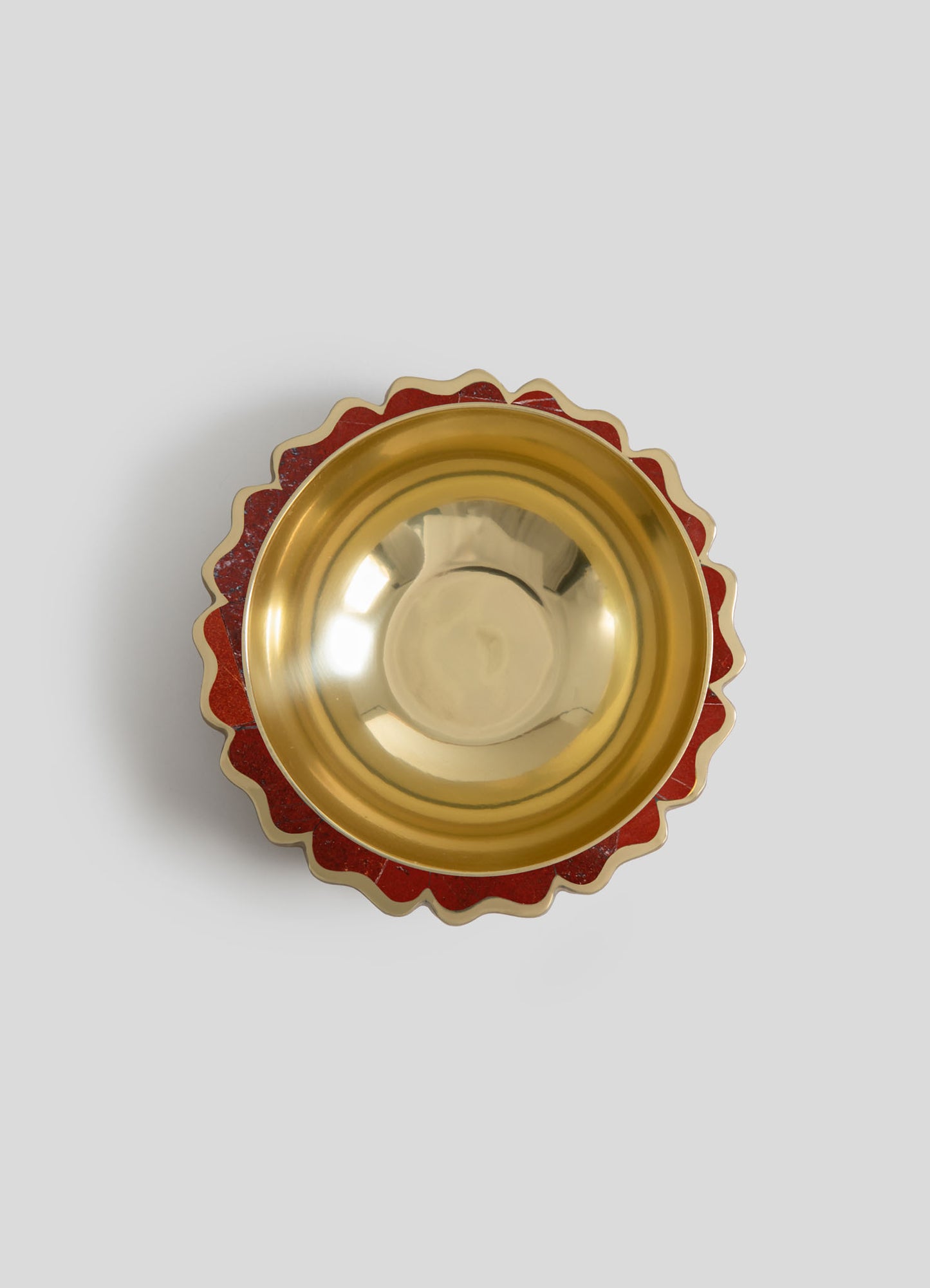 A decorative bowl with a gold interior and a scalloped red and gold patterned exterior, featuring a glossy finish and ornate design.
