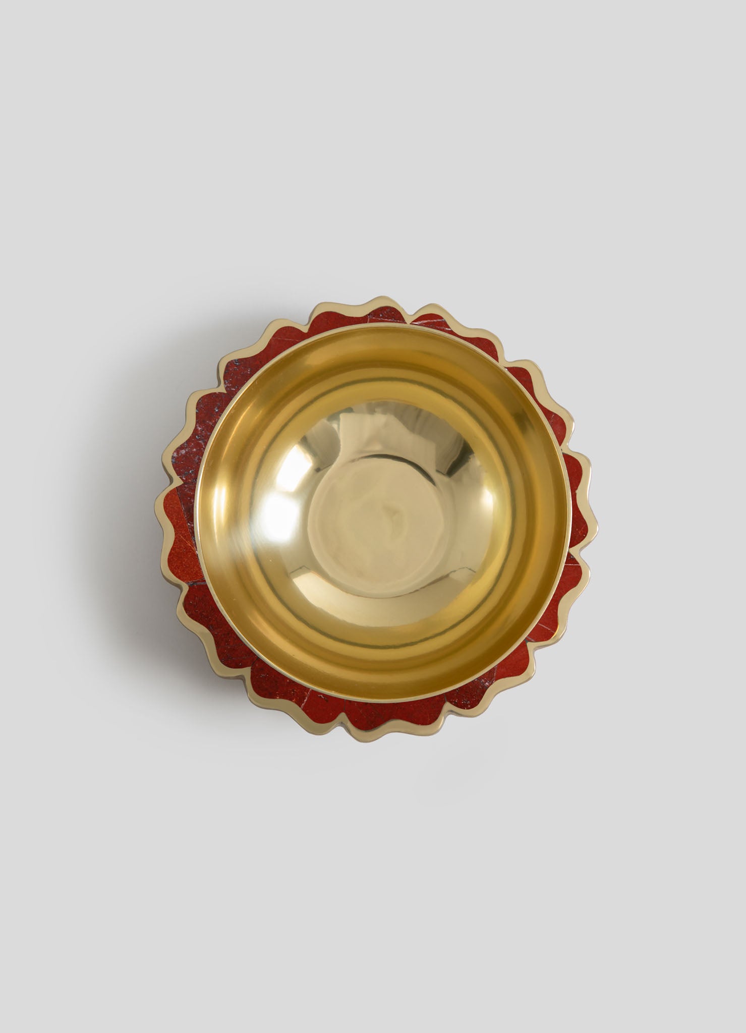 A decorative bowl with a gold interior and a scalloped red and gold patterned exterior, featuring a glossy finish and ornate design.