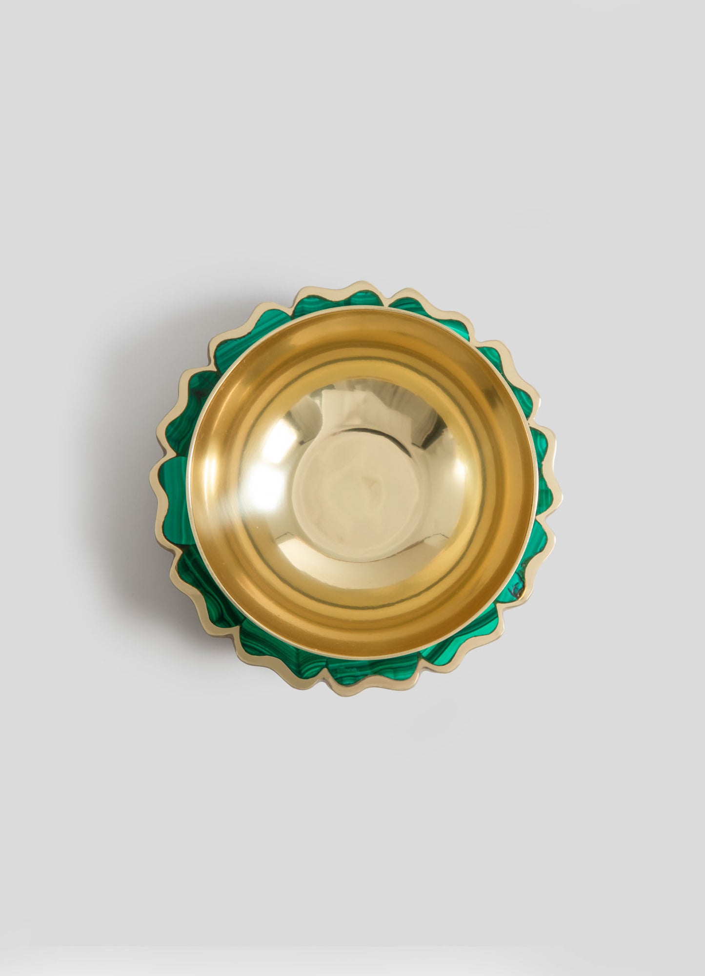 Metallic gold bowl with a smooth, reflective interior and a scalloped edge featuring green and gold accents, designed with a decorative pattern.