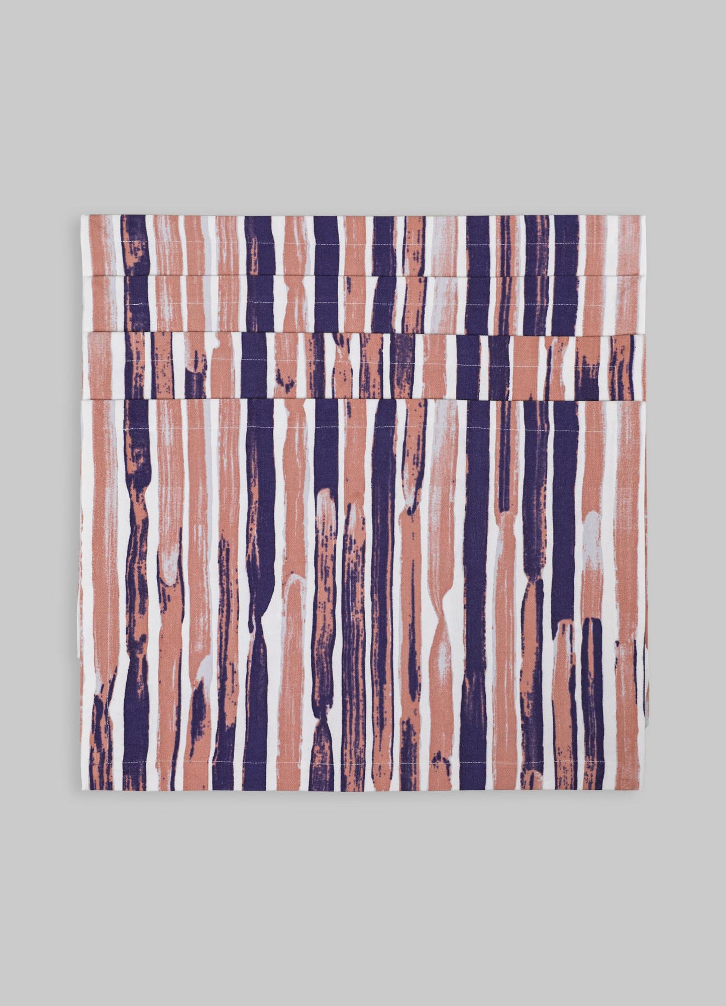 A textile piece with a vertical striped pattern in shades of peach, navy blue, and white, featuring irregular, painterly brushstroke-like motifs on a light background.