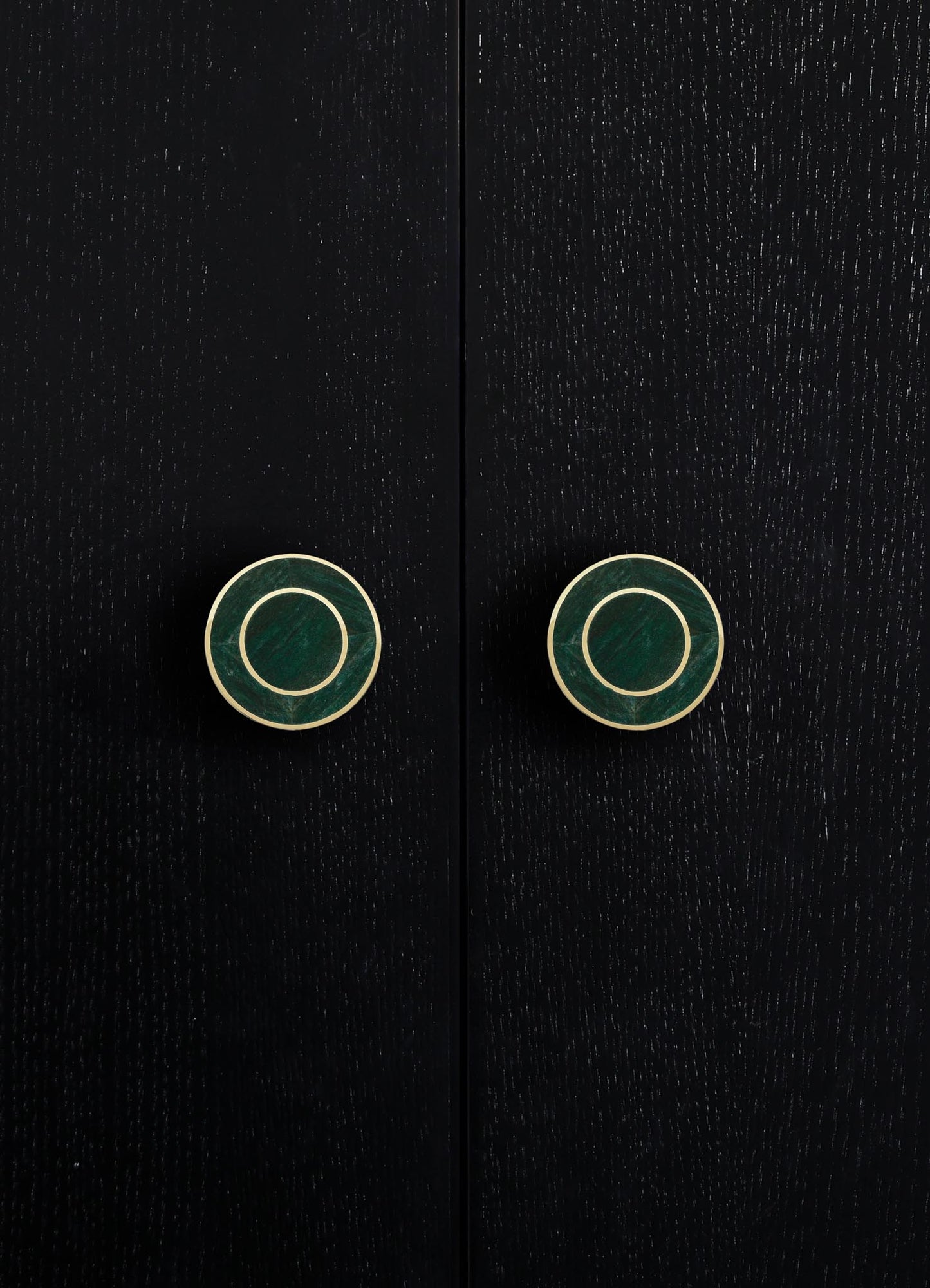 Black wooden cabinet with textured surface and round metallic gold and green drawer pulls. The style appears contemporary with a sleek, minimalist design.