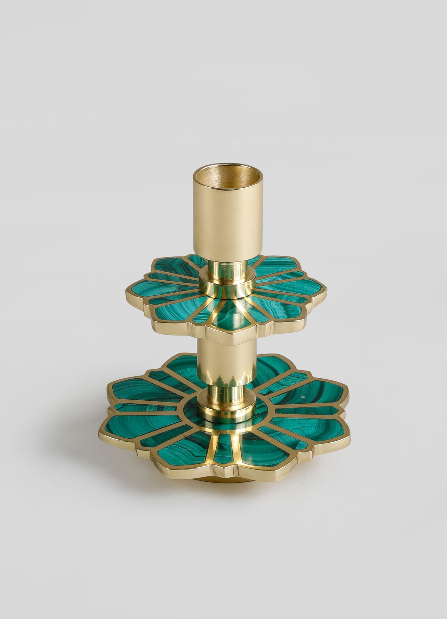 A decorative candle holder with a brass finish and two layered floral-shaped bases featuring turquoise malachite inlays, designed for a modern, luxury aesthetic.