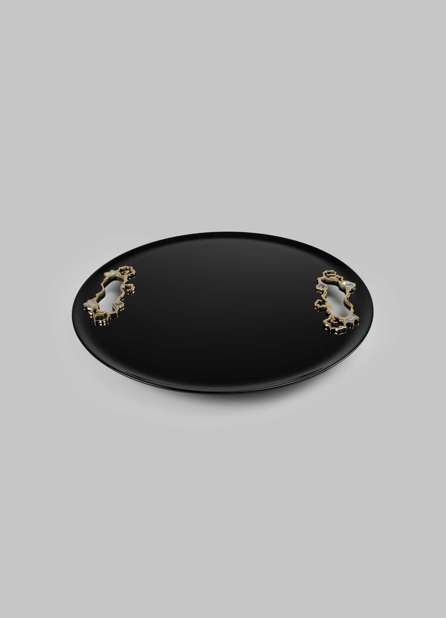 A black oval tray with a glossy finish, accented by two gold-toned decorative handles with ornate, floral motifs.