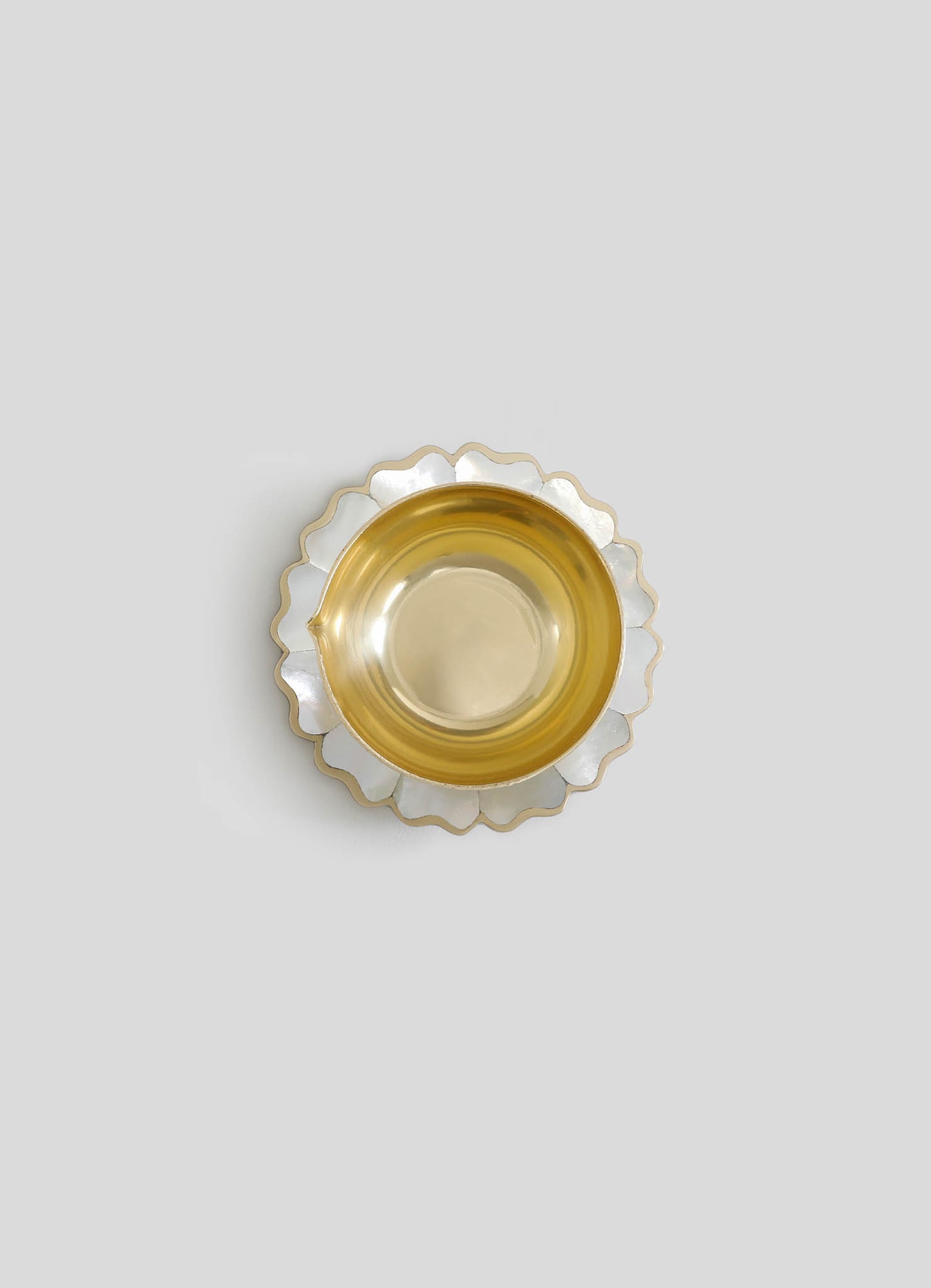 A decorative tray with a scalloped edge featuring silver and gold metal finishes. The inner surface is smooth and reflective, with the outer edge having a wavy design.