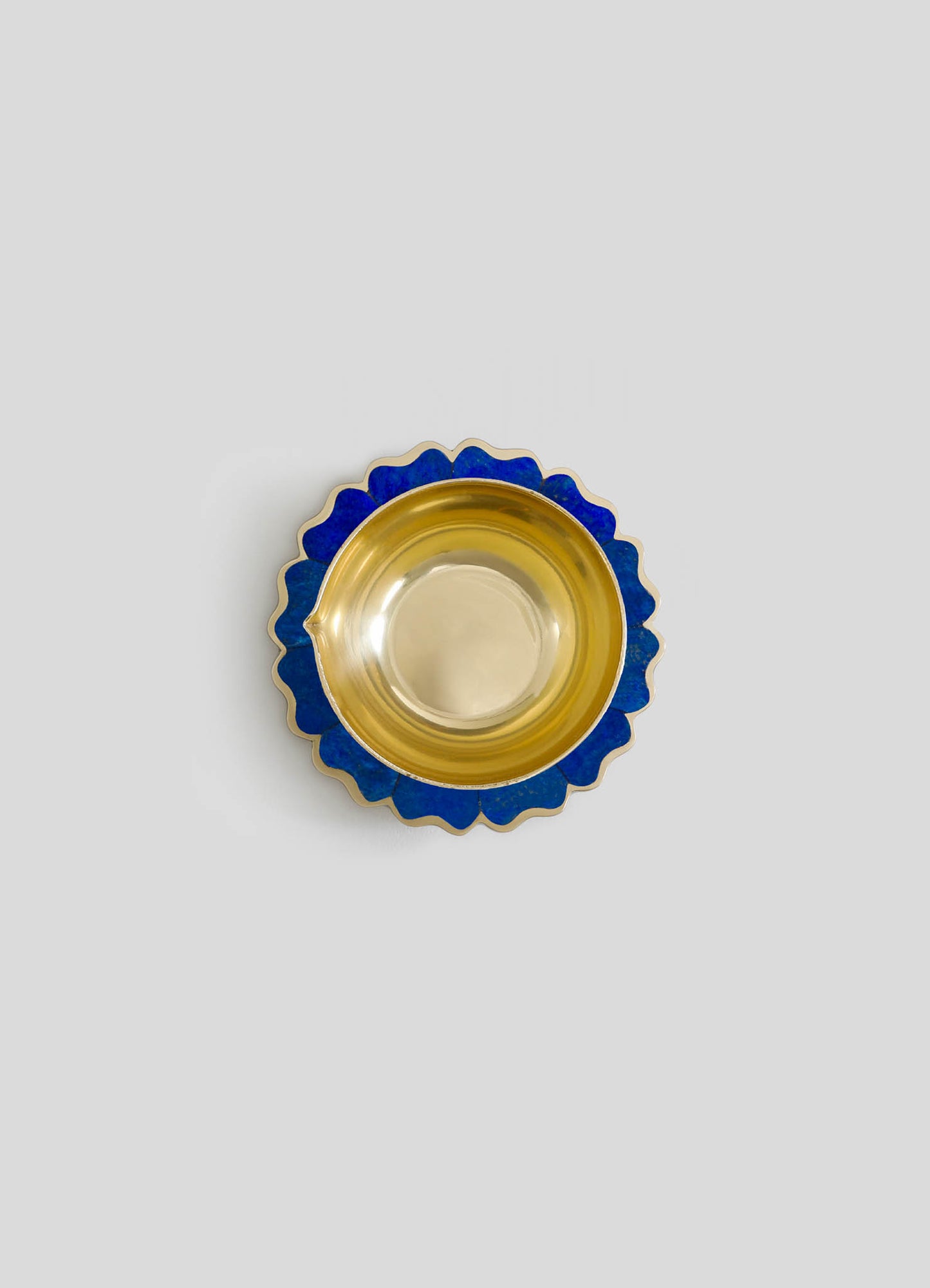 A decorative bowl with a gold interior and a scalloped blue exterior pattern.