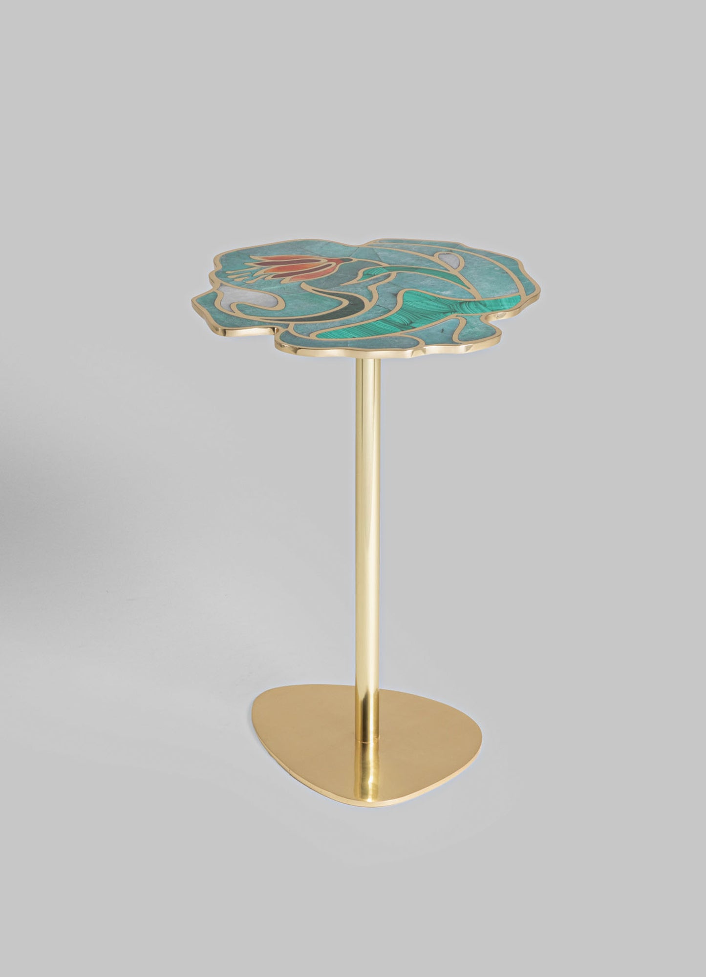 A side table with a brass base and a scalloped top featuring a colorful, abstract pattern in shades of blue, teal, and orange. The design on the tabletop appears handcrafted with a smooth, polished finish.