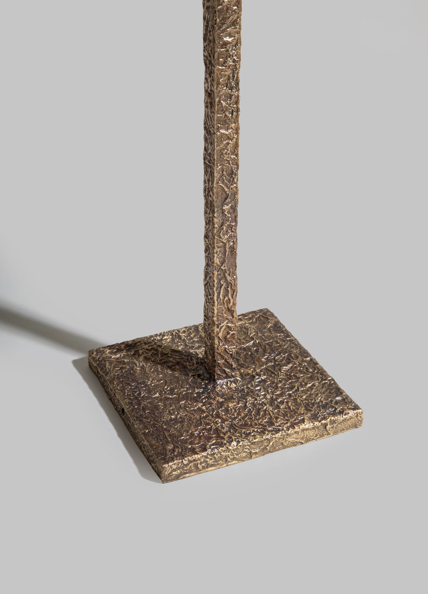 Brass table lamp with a textured, hammered finish on a square base, featuring a tall, narrow body and a metallic gold tone.
