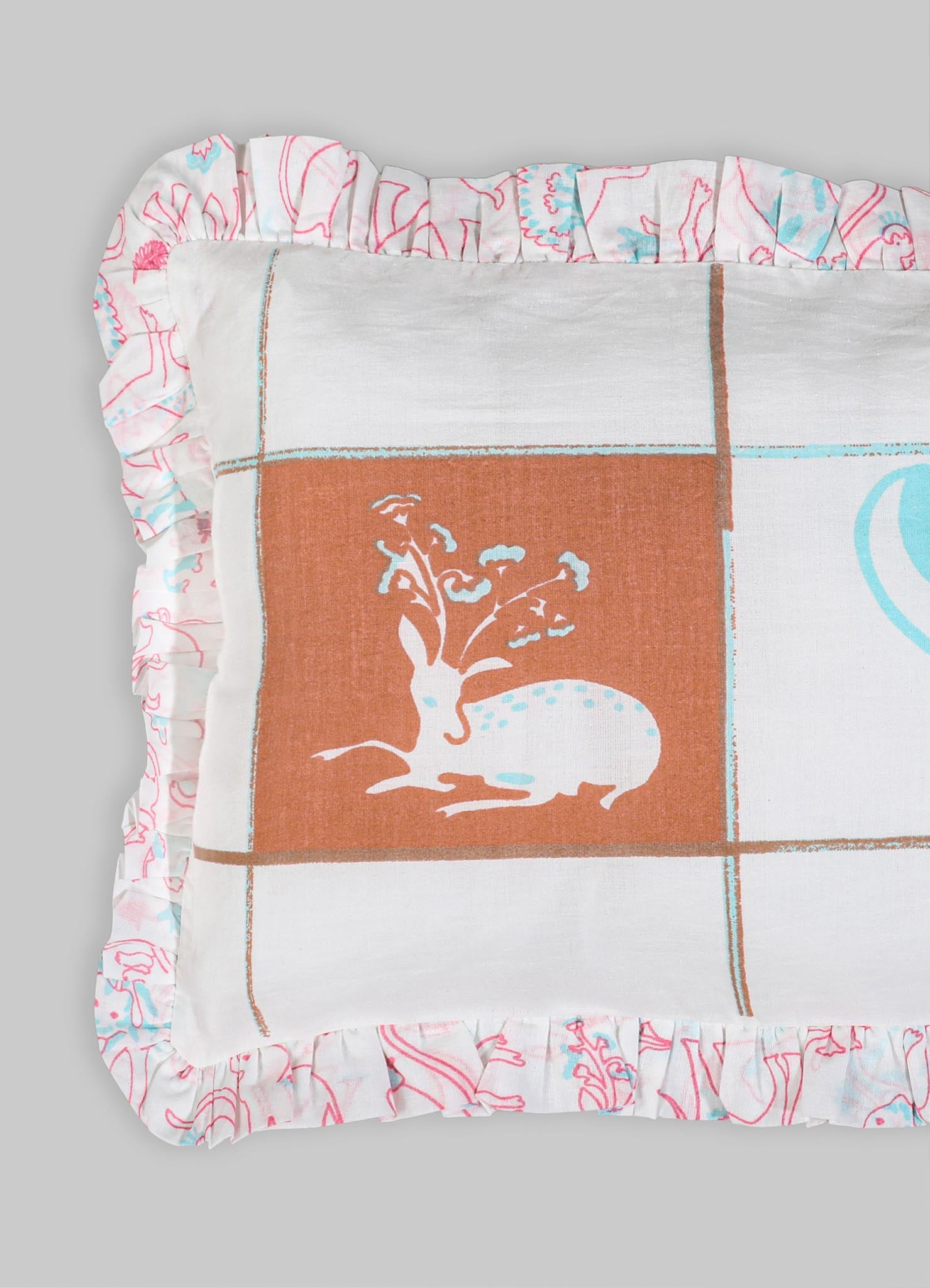 Decorative pillow with a printed textile featuring a stylized animal motif and floral illustration, bordered by ruffled fabric with abstract line art in pink and blue tones.