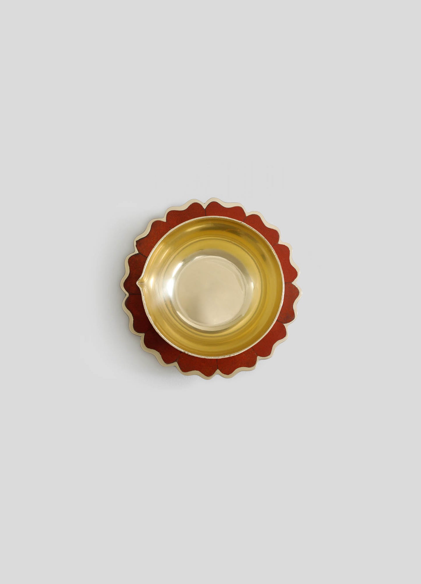 A decorative bowl with a gold-tone interior and a scalloped wooden outer edge in a reddish-brown finish.