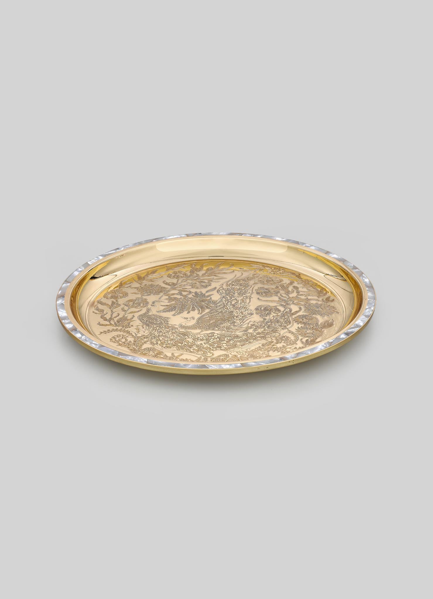 Gold-toned metal tray with intricate engraved floral and bird motifs, featuring a clear beveled glass border detail.