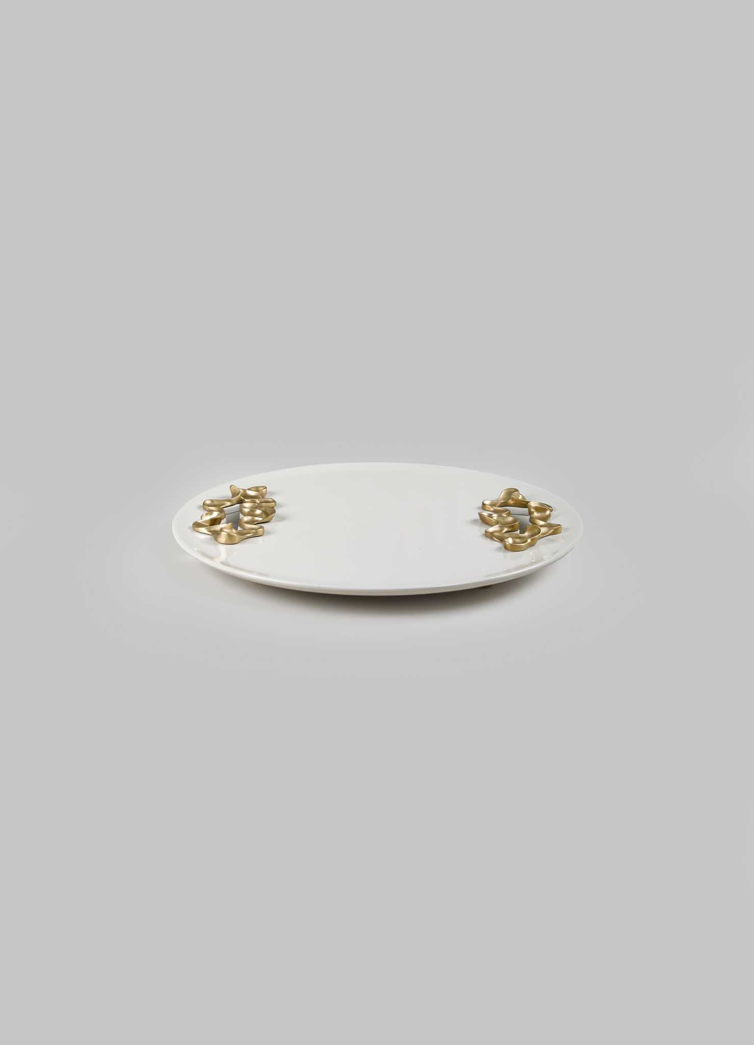 A white ceramic tray with an oval shape, decorated with gold-tone metallic accents that resemble intertwined loops on each end.