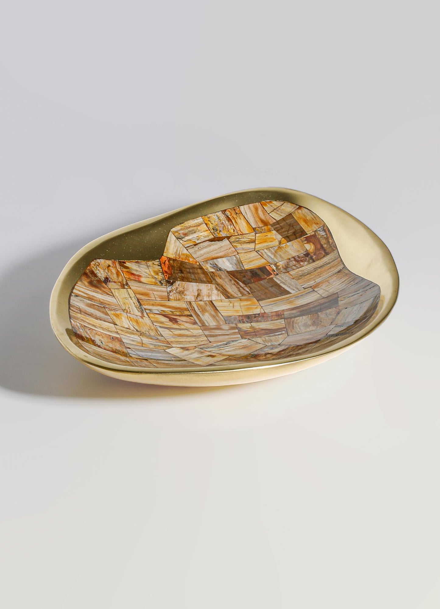 A decorative ceramic dish with a glossy beige exterior and an interior featuring a geometric mosaic pattern in earthy tones of brown, orange, and cream. The oval-shaped dish has a smooth, curved rim and a handcrafted appearance.