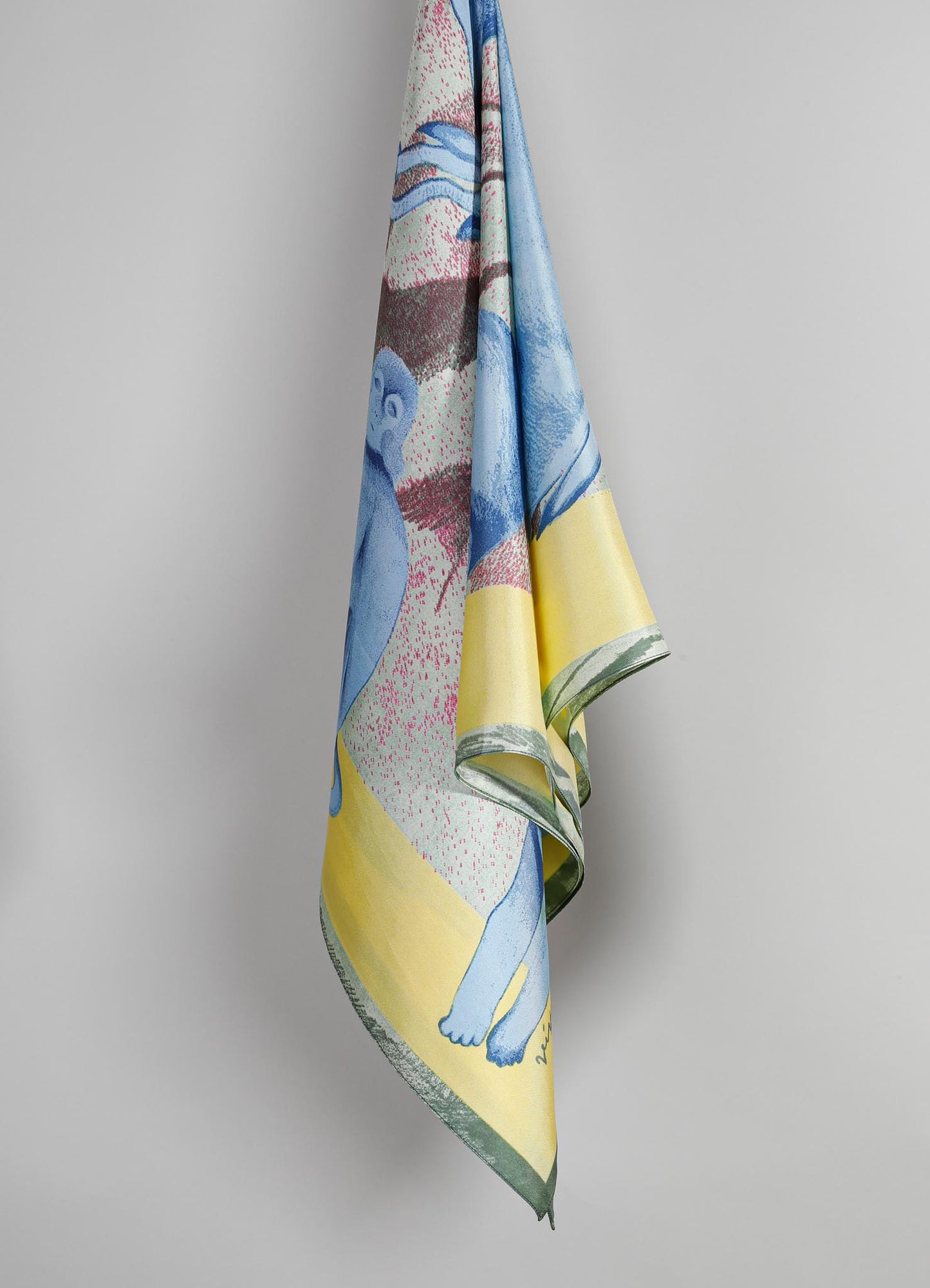 A textile or scarf featuring a colorful, artistic print with abstract and figurative motifs in shades of blue, pink, yellow, and green. The fabric appears lightweight with a smooth texture and a soft sheen, displayed against a plain background.