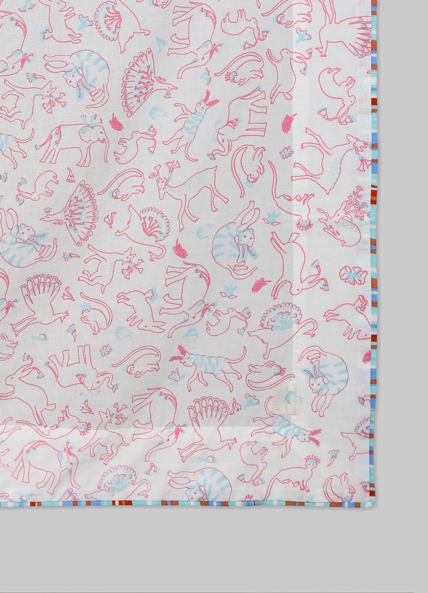 Cotton tablecloth featuring a playful pattern of pink and blue outlined animals including dinosaurs, birds, and mammals, with a multicolored striped border. The fabric has a light, airy appearance, suitable for casual or children's dining settings.