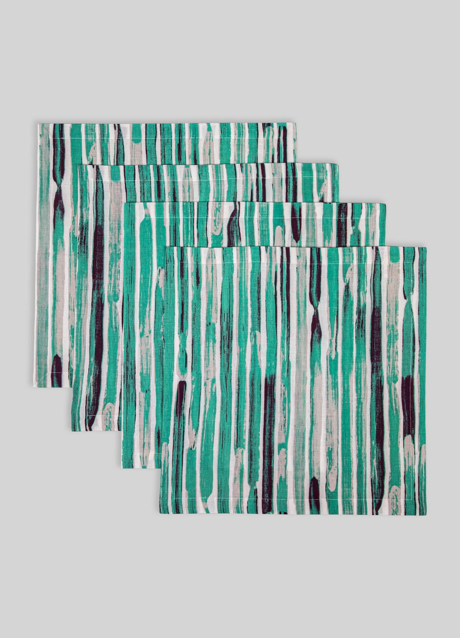 Set of three fabric placemats featuring an abstract vertical stripe pattern in shades of teal, black, and white, made from a smooth material with cleanly finished edges.