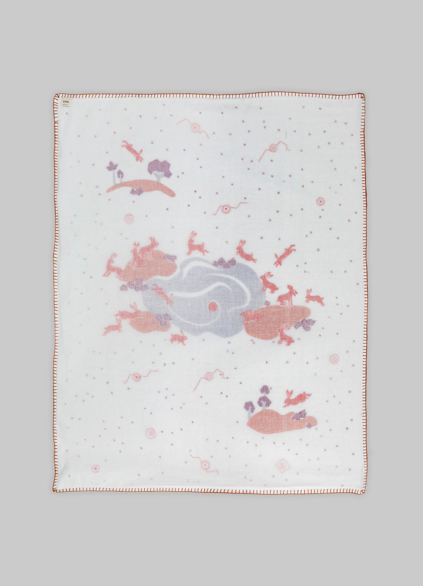 A baby blanket made of soft fabric featuring a whimsical print of animals and abstract shapes in pastel pink and purple tones, with a stitched border in matching color.
