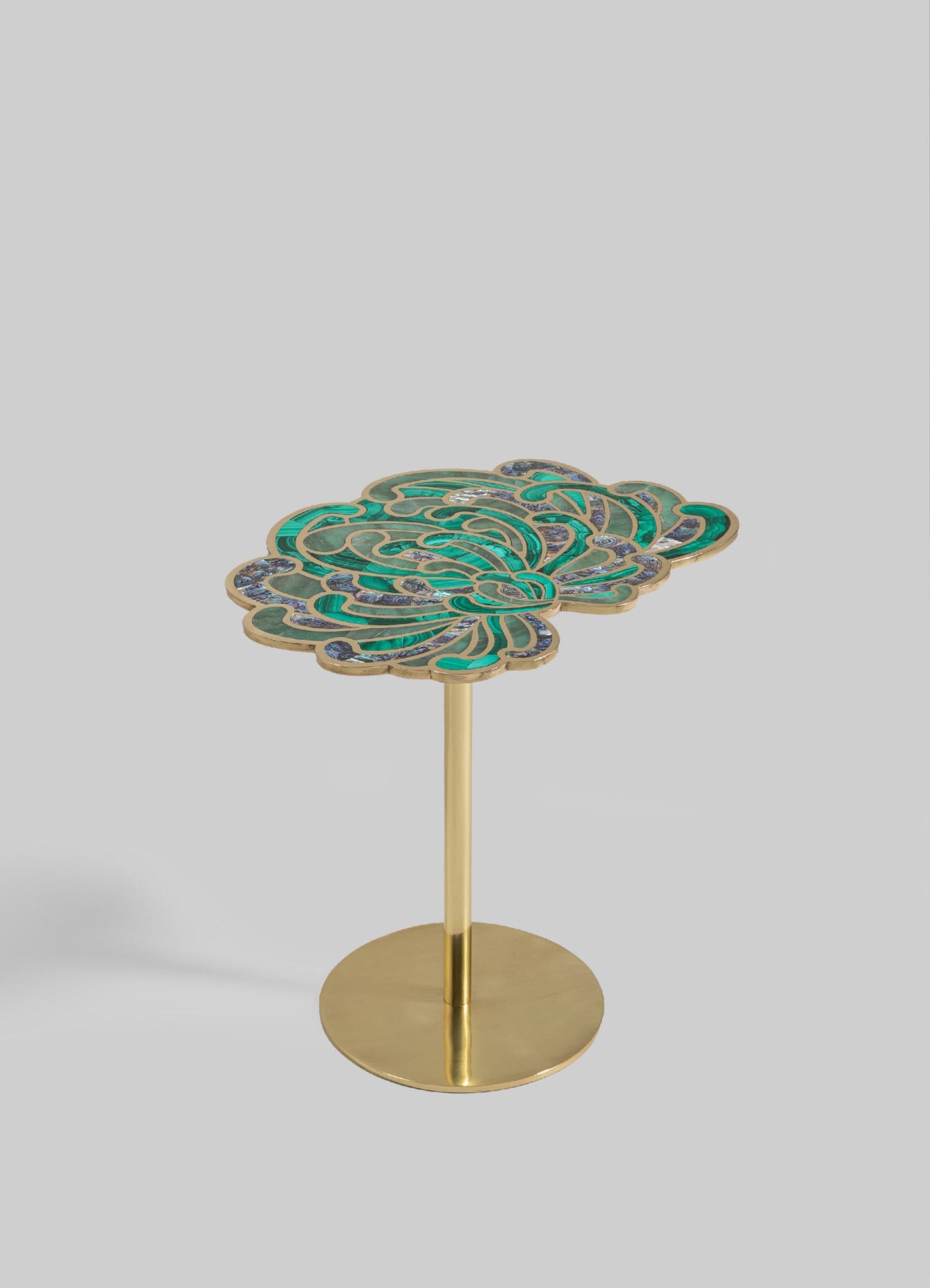 A decorative side table with a floral-inspired top made of colored enamel and metal in shades of green and blue, supported by a slender gold-colored metal stem and round base.