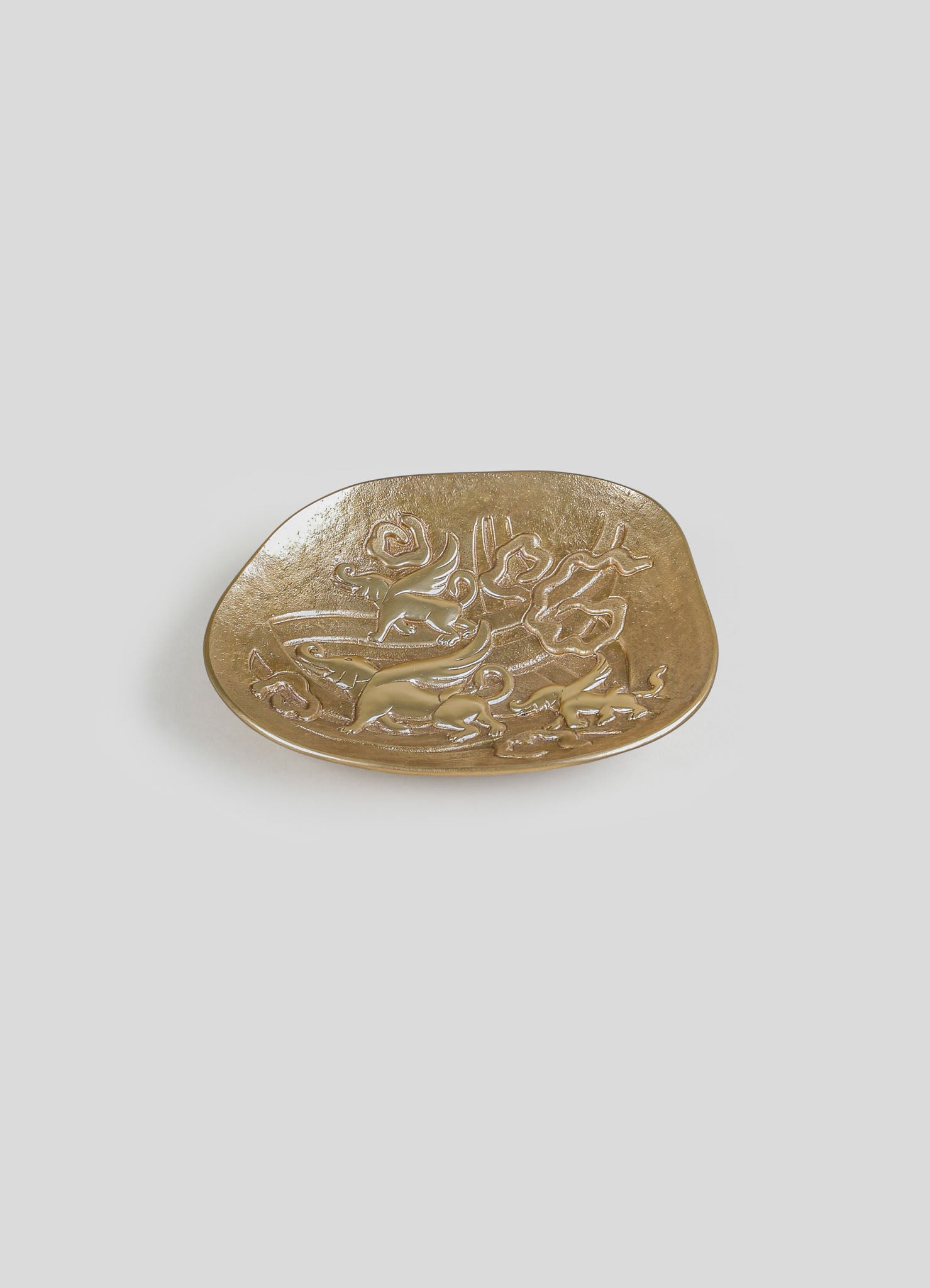 A decorative gold-colored tray with embossed floral and animal motifs, made of metal with a smooth, rounded rectangular shape.