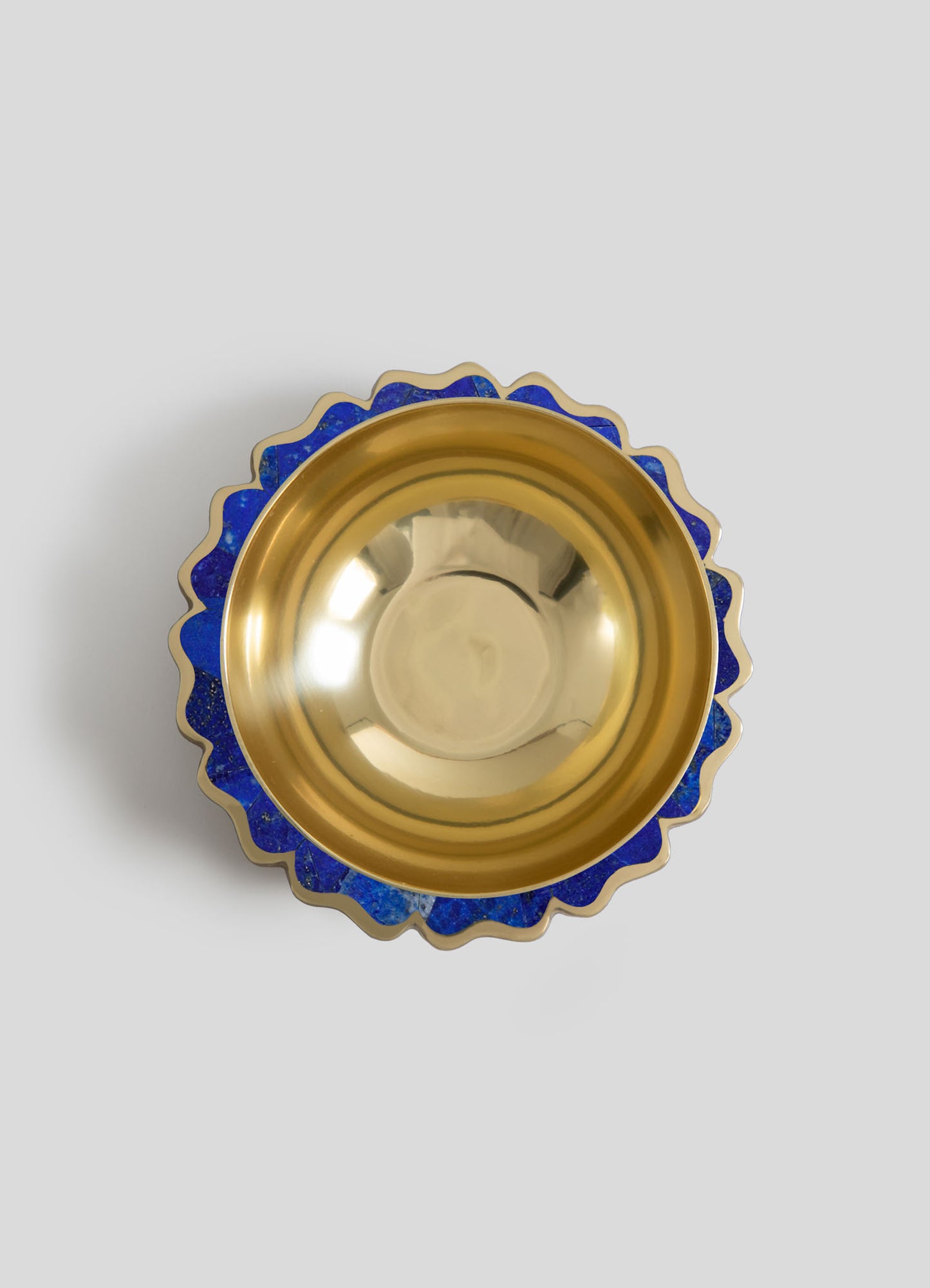 Decorative bowl with a gold interior and a scalloped edge featuring blue mosaic accents, made of ceramic or glass.