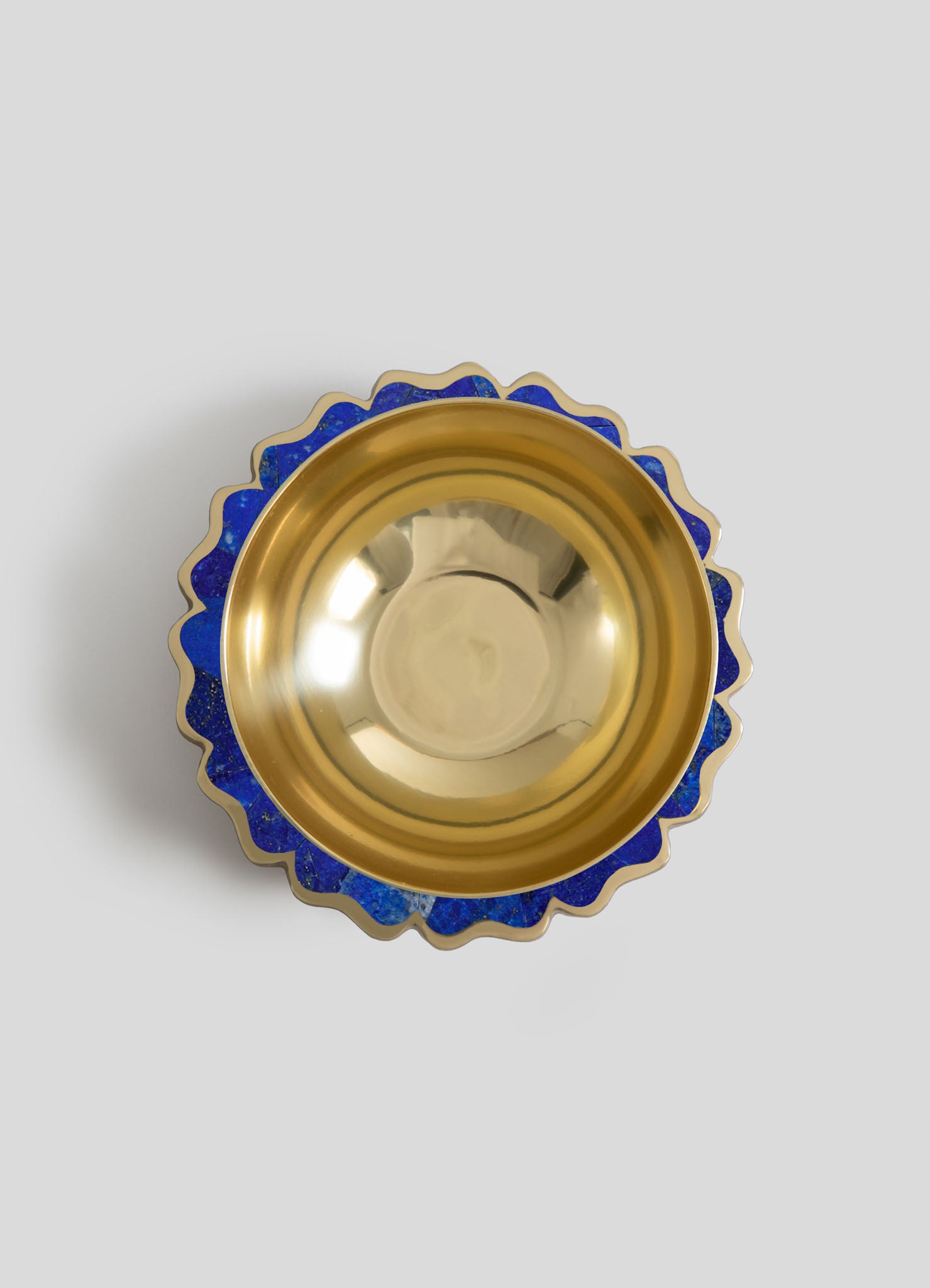 Decorative bowl with a gold interior and a scalloped edge featuring blue mosaic accents, made of ceramic or glass.