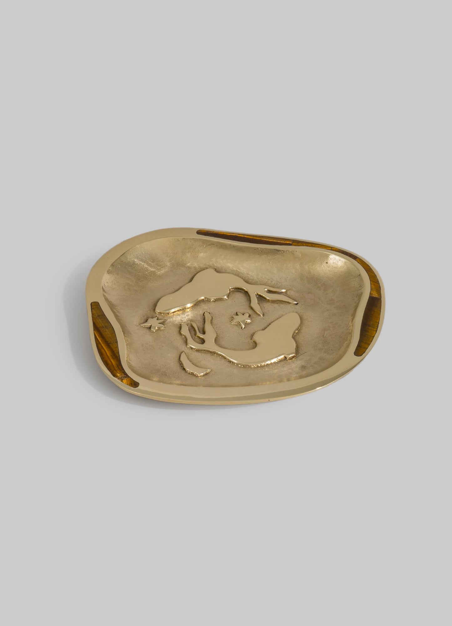 A decorative tray made of polished metal with a gold-tone finish, featuring an embossed map of the world and small engraved stars, with wood accents on the edges.