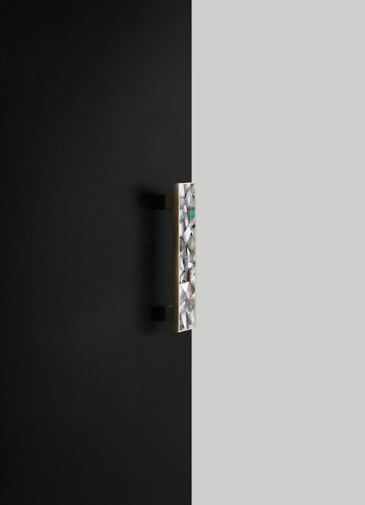 A wall-mounted decorative piece with a rectangular shape, featuring an inlay of iridescent shell or mosaic tiles arranged in a pattern, mounted on a neutral-colored wall.