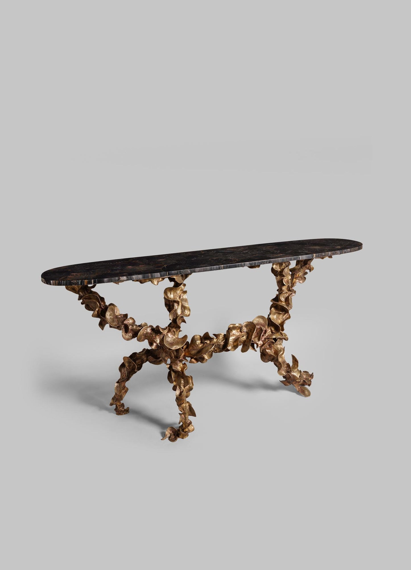 A console table with a dark, polished wooden top and a sculptural base made of intertwined metallic gold elements, featuring an organic, botanical-inspired design.