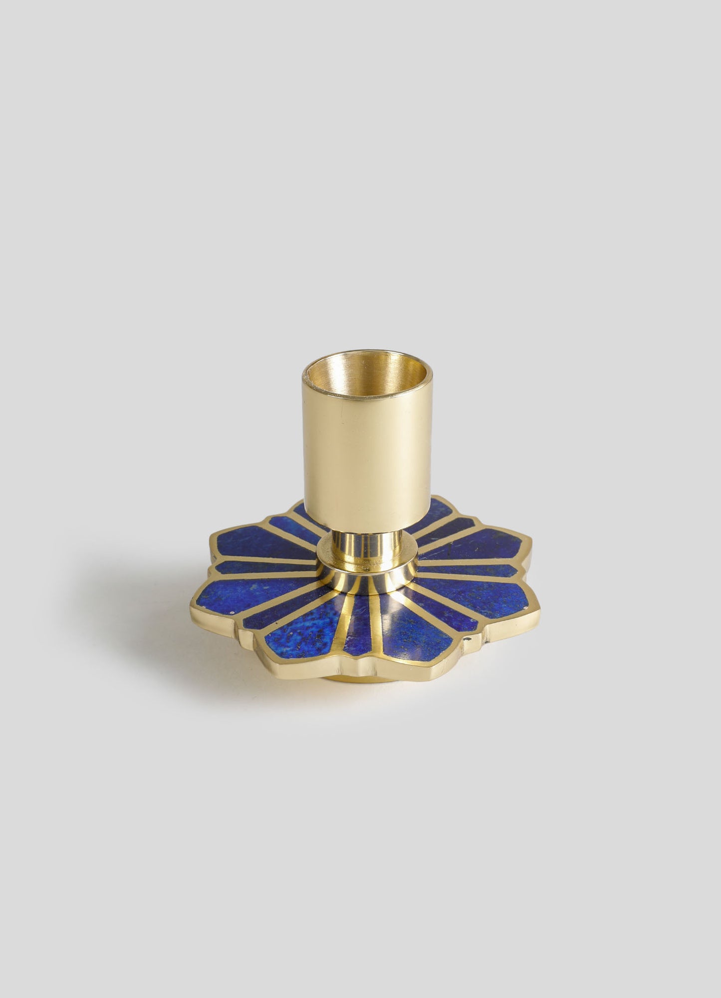 A candle holder with a gold finish and a blue inlay design, featuring a flower petal motif base and a cylindrical holder for a candle.