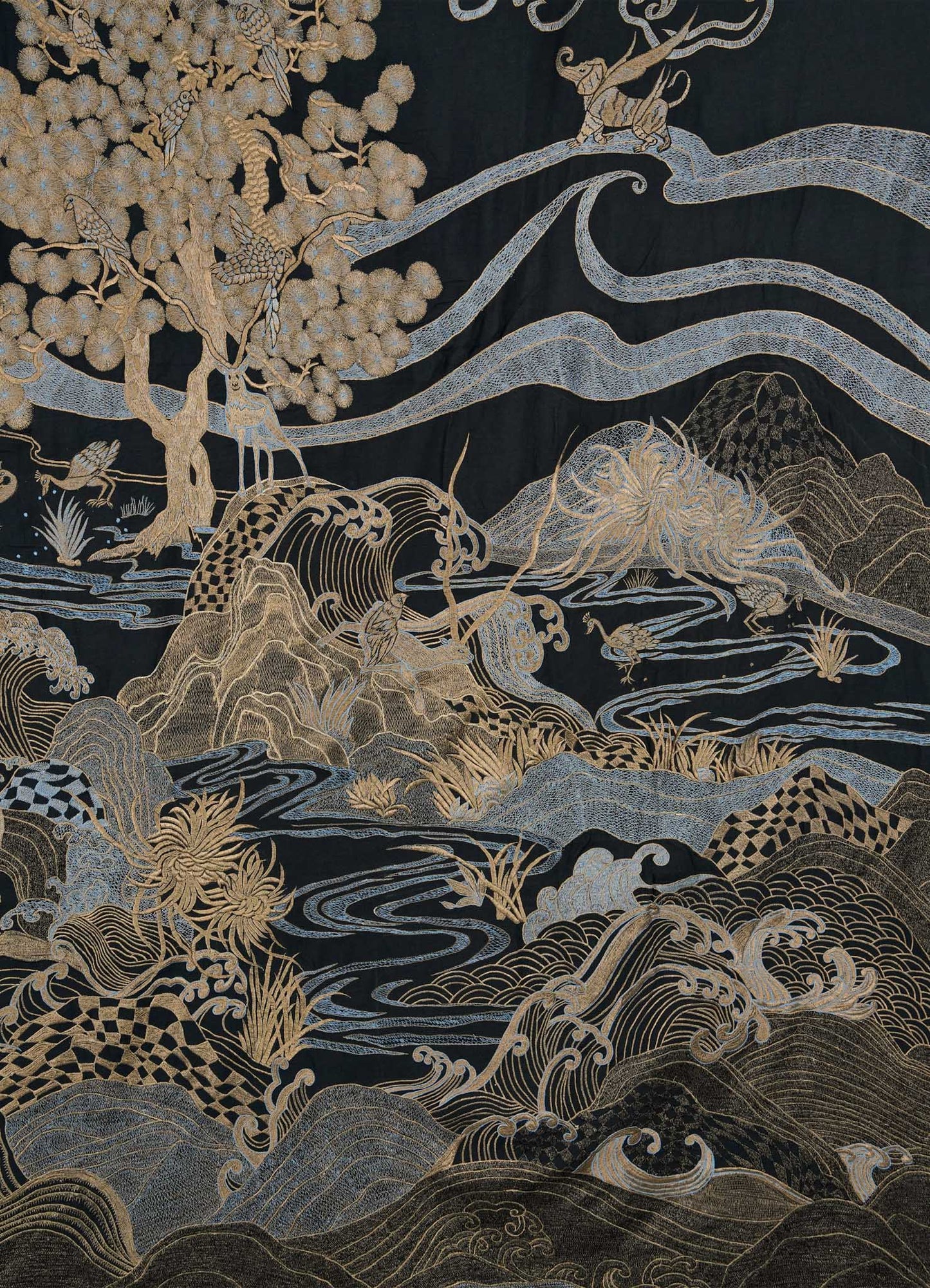 The Viya Dreamscape Black & Gold Embroidered Bedcover showcases swirling waves, mountains, golden trees, and silver clouds in detailed Rajput-inspired patterns on black, creating an ornate and symbolic textile masterpiece.