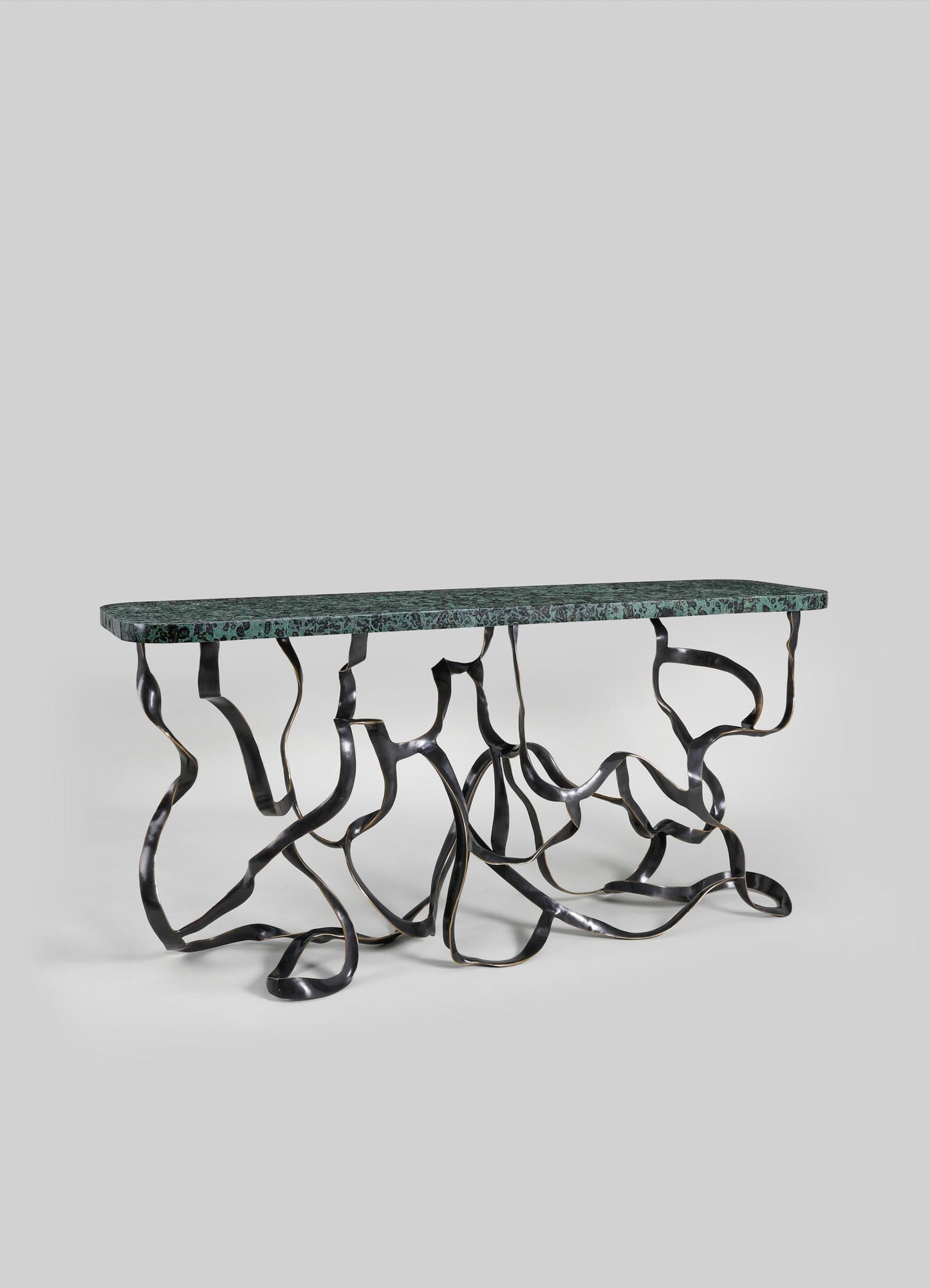 A decorative table with a dark green marble top and a sculptural metal base featuring twisted, organic-shaped legs in black and metallic finish.