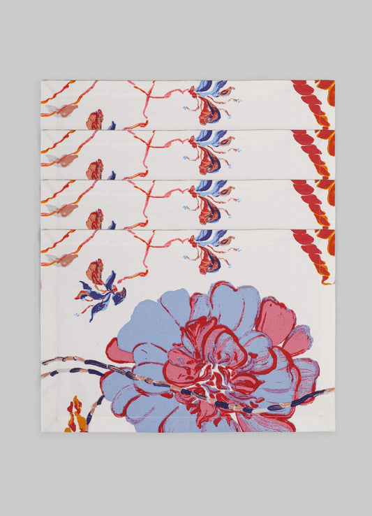 Folded table napkins with a floral pattern featuring large blue and red flowers and orange accents on white fabric, arranged in a fan shape. The design has an artistic, painterly style with bold, expressive brushstrokes.