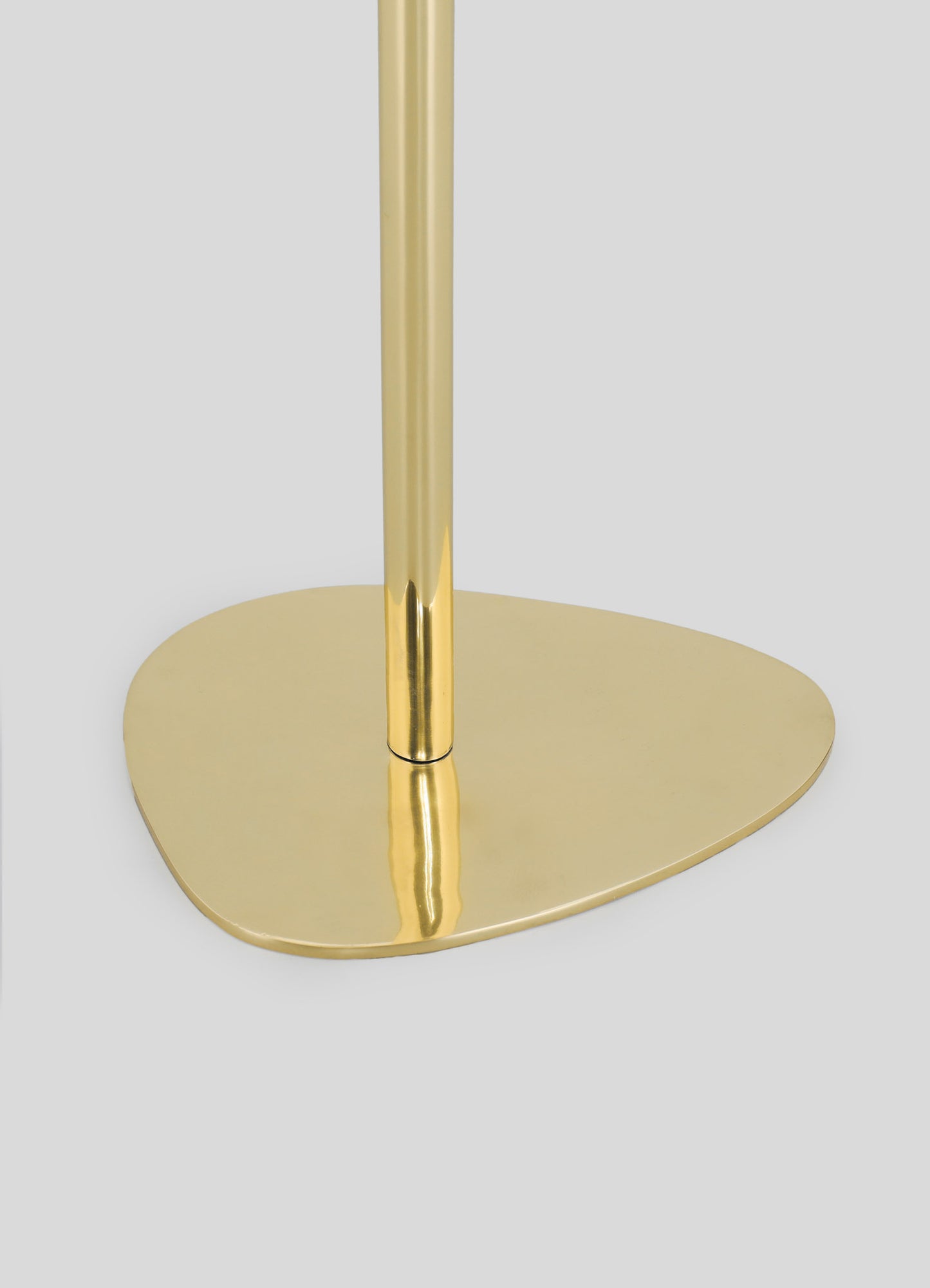 A brass lamp with a rounded base and cylindrical stem, featuring a polished metallic gold finish.