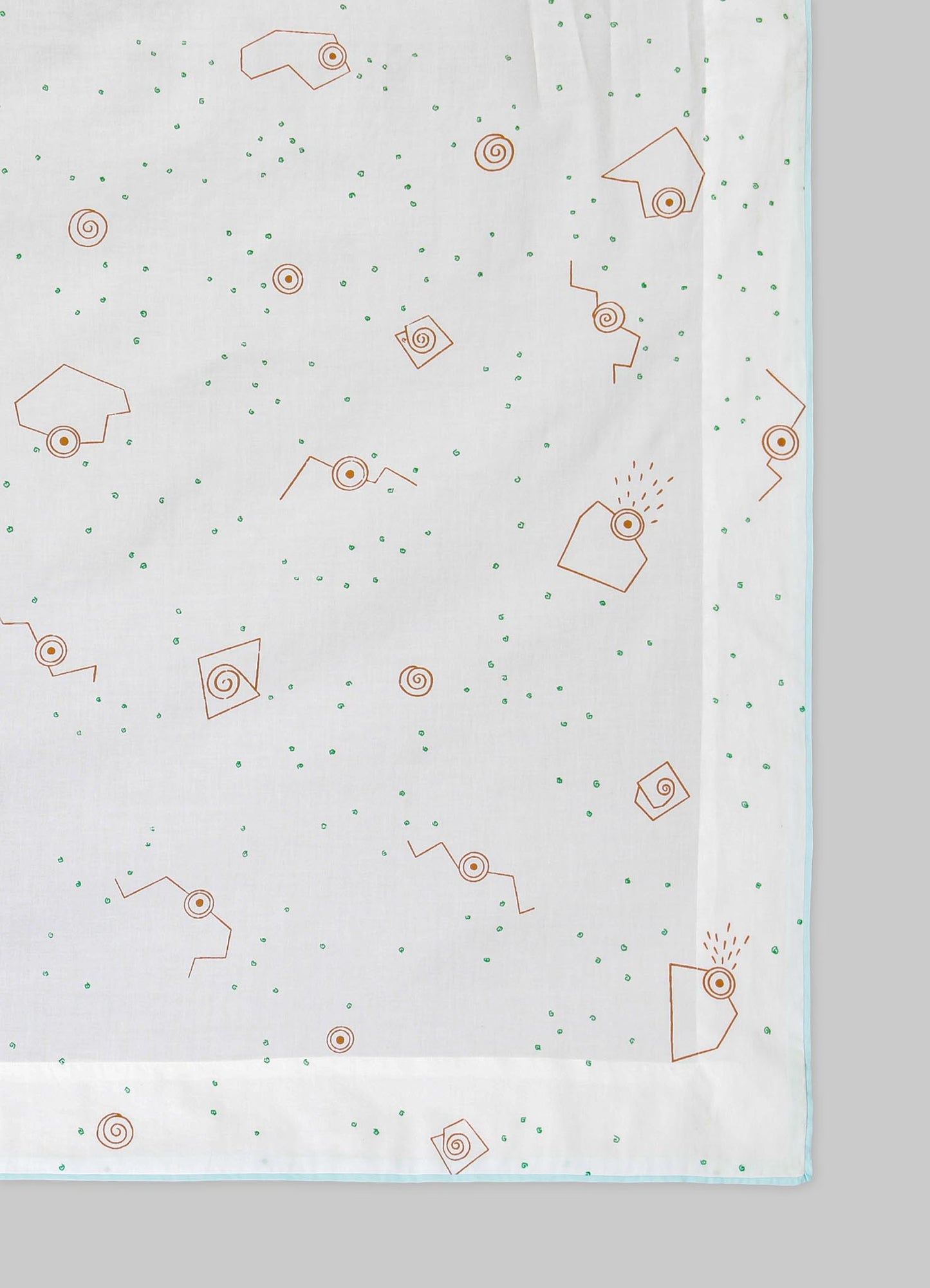 A white tablecloth with a minimalist geometric pattern featuring orange spiral and square motifs, accented by small green dots scattered across the fabric. The edges of the tablecloth are finished with a light blue trim.