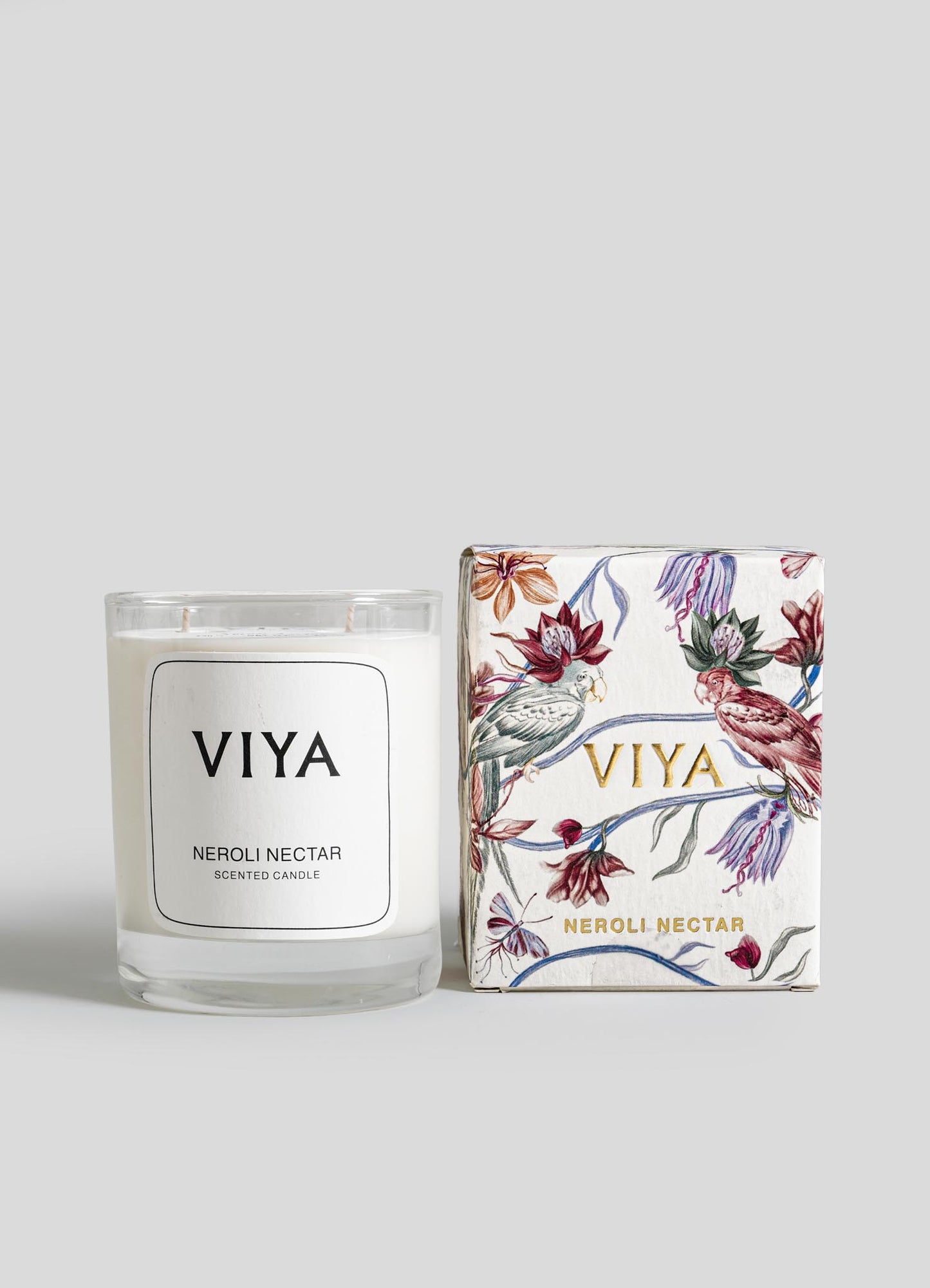 VIYA Neroli Nectar candle and its packaging on a light gray background viya luxury wax candle stand