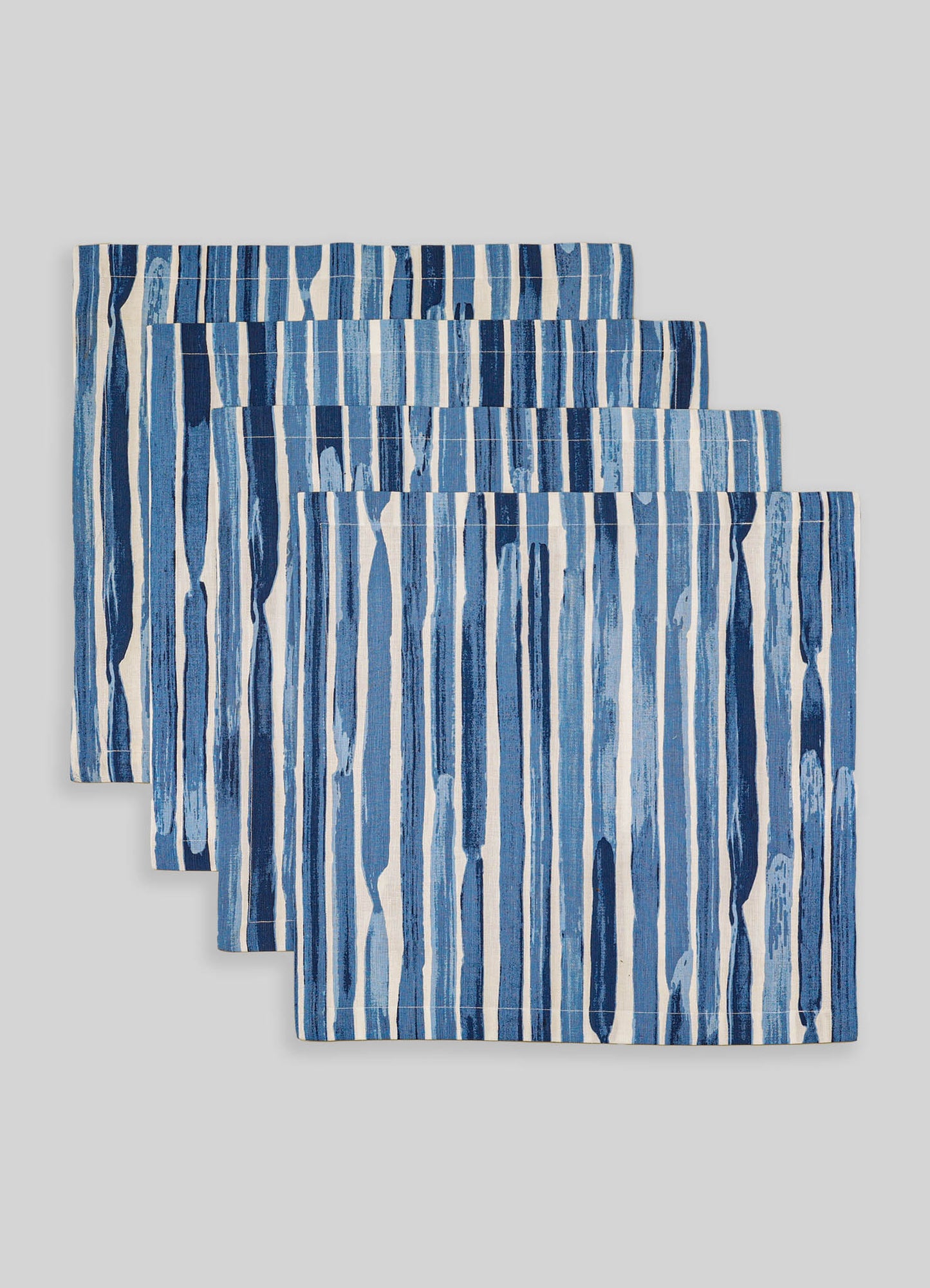 Set of three cotton table placemats featuring vertical blue and white abstract stripe patterns, with a contemporary and casual style.