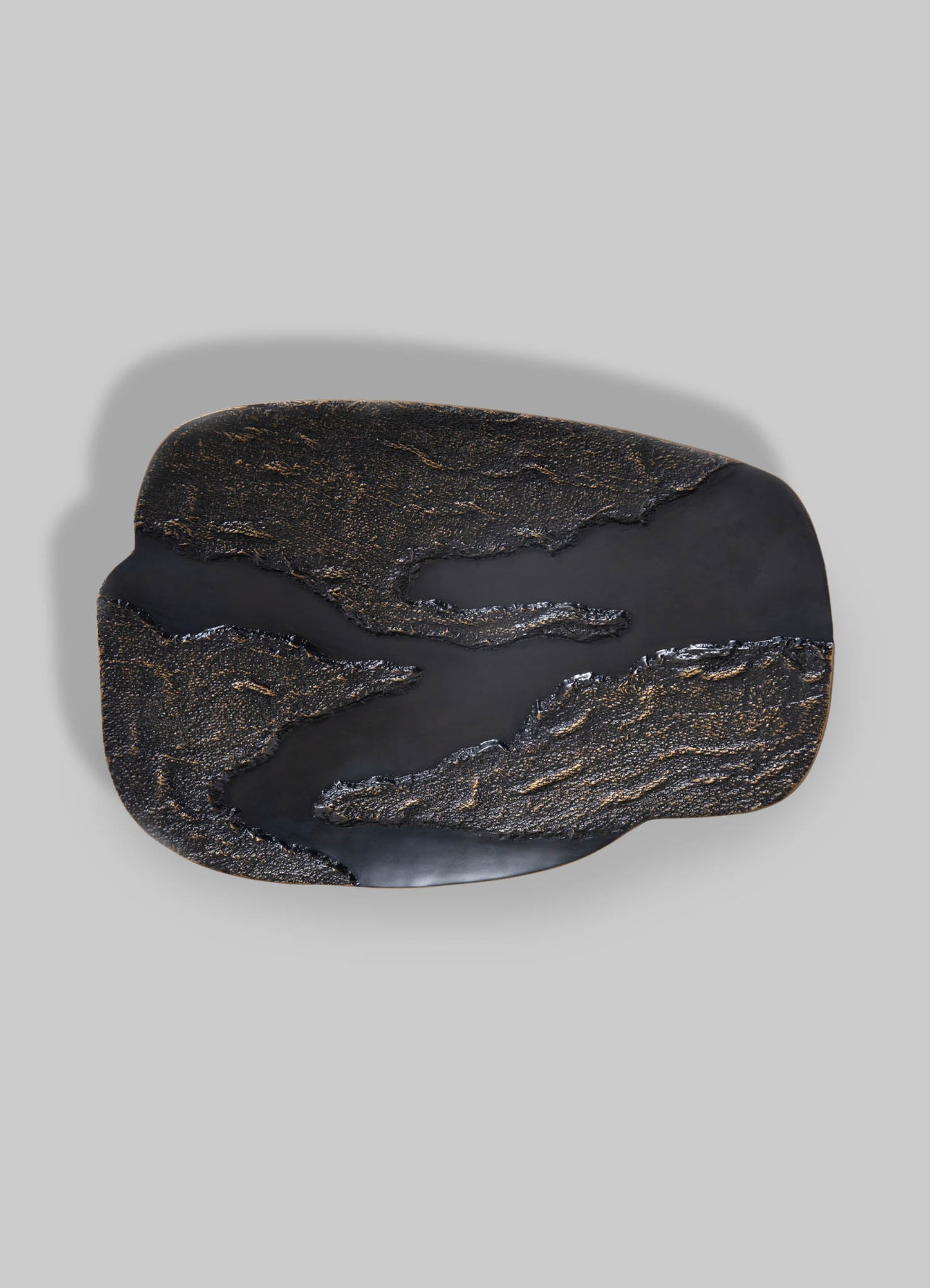 A black and gold textured tray with abstract organic shapes and a matte finish, made from metal or similar material, against a plain background.