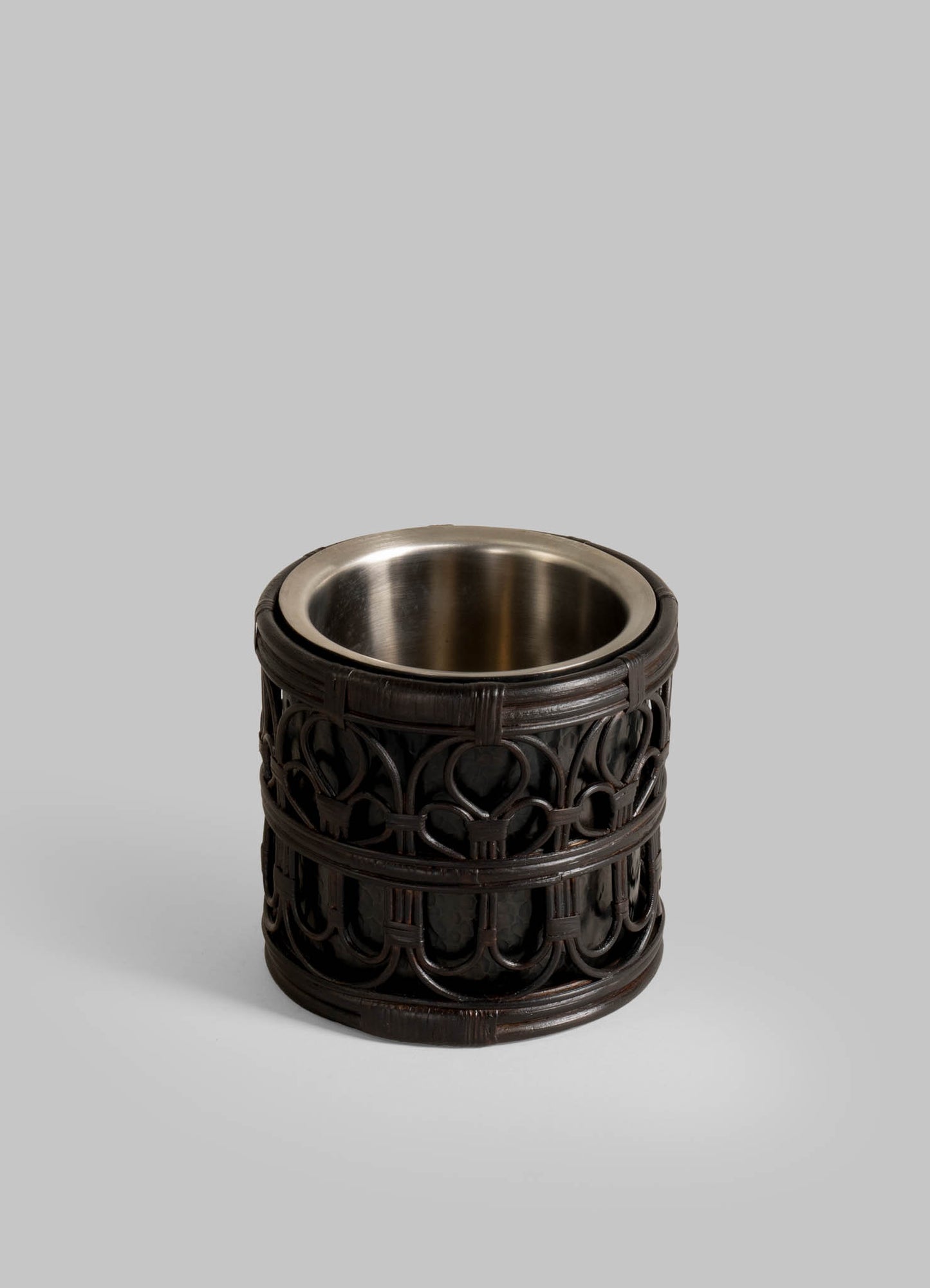 The VIYA Manipur Ice Bucket Small features an ornate, dark metal exterior with intricate gothic patterns and a smooth metal inner section, making it a sophisticated addition to any barware collection.