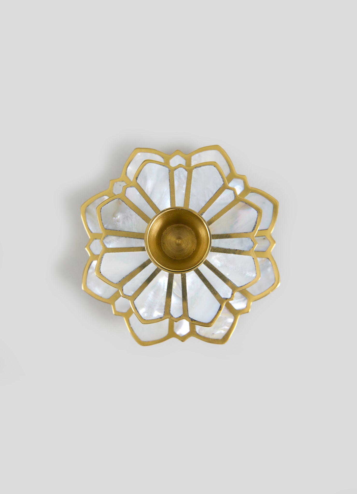A ceiling light fixture featuring a gold metal frame and a floral-inspired design with petal-shaped components, accented by iridescent mother-of-pearl or shell-like panels. The fixture has a central brass or gold-tone socket for a bulb.
