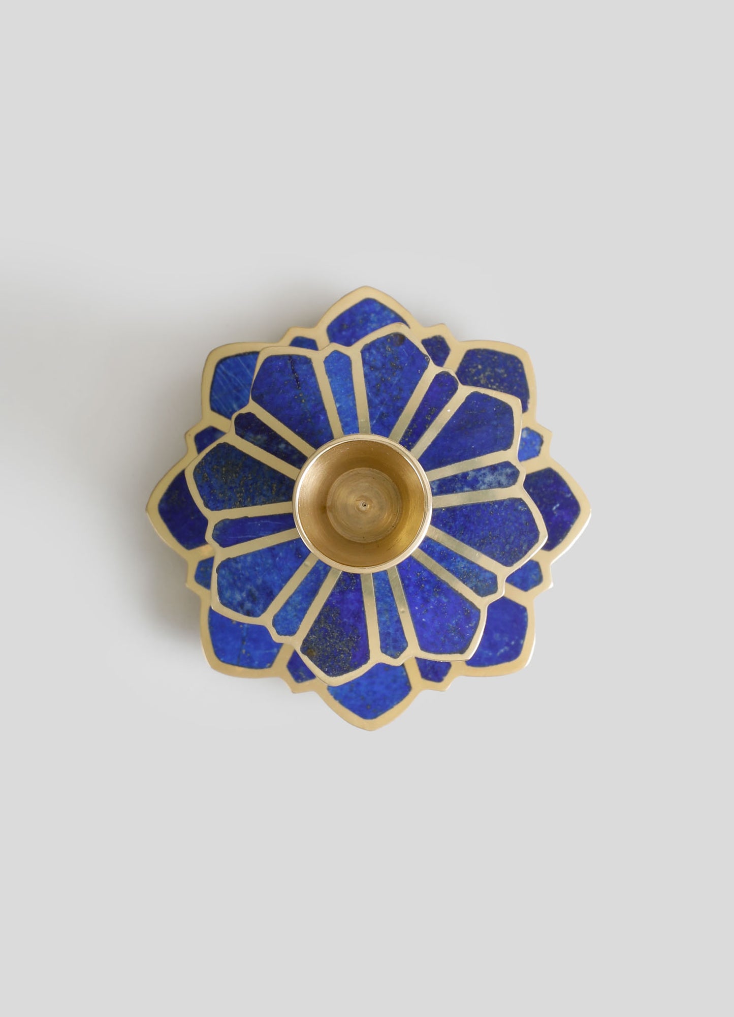 A decorative candle holder featuring a lotus flower shape with blue lapis lazuli inlay and gold-colored metal accents, designed to hold a small candle or tealight.