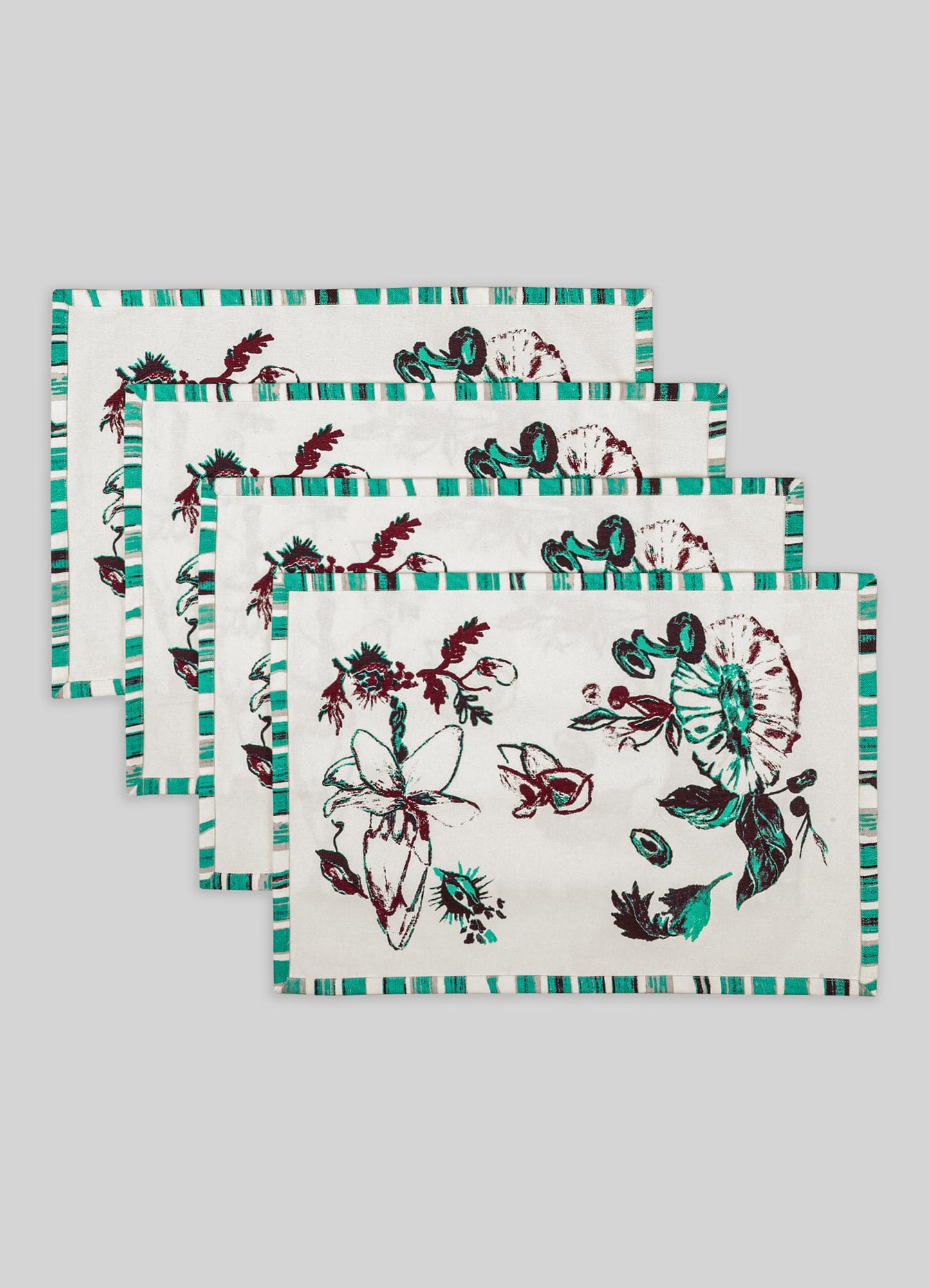 Set of fabric placemats with floral and butterfly motifs, featuring a white background with red, green, and black printed designs. The placemats have a striped border in shades of teal and white, giving a contemporary, handcrafted appearance.