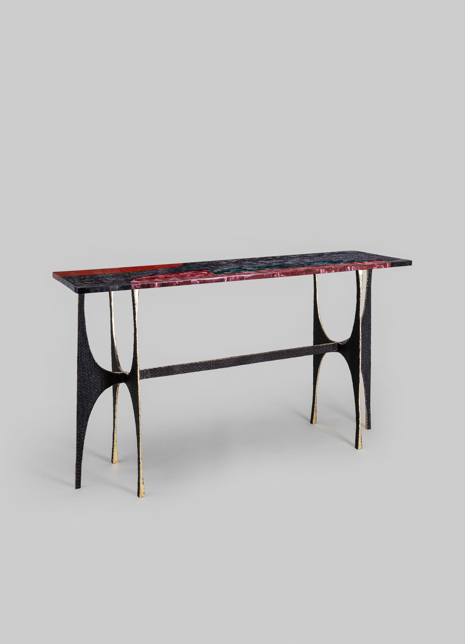 A console table with a multicolored marble top featuring shades of black, red, and green, supported by a black metal frame with gold accents on the edges and legs.