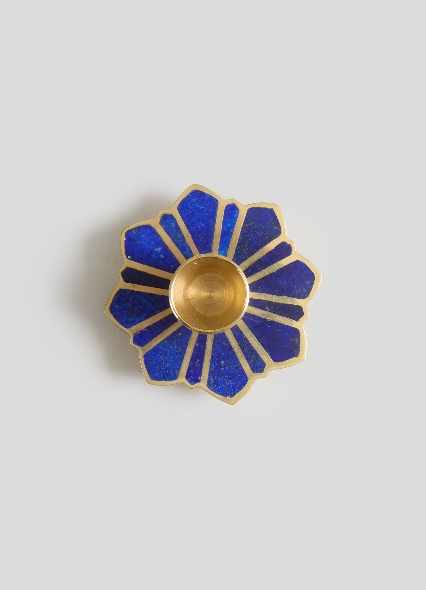 A decorative blue and gold flower-shaped dish with a central gold bowl, featuring geometric blue enamel segments edged in gold.